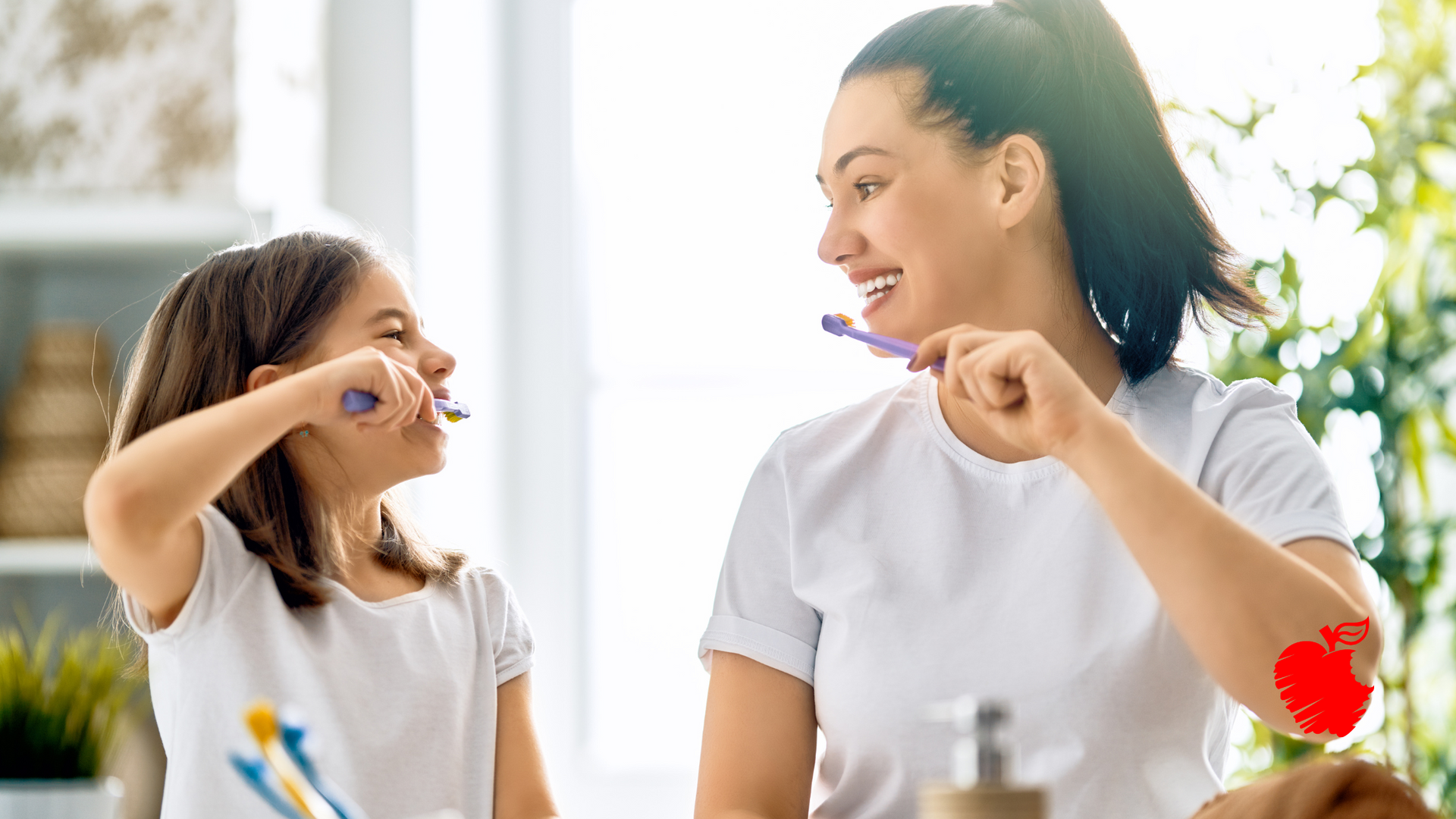 A woman and a little girl are brushing their teeth together.
