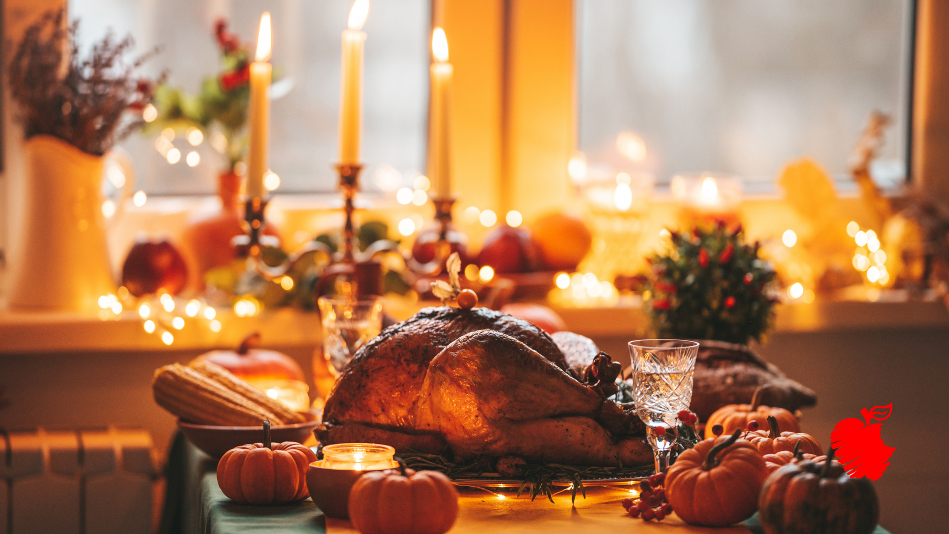 A turkey is sitting on a table with pumpkins and candles.