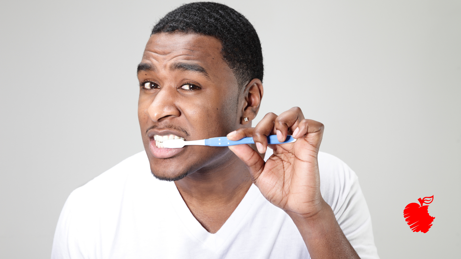 A man is brushing his teeth with a blue toothbrush.