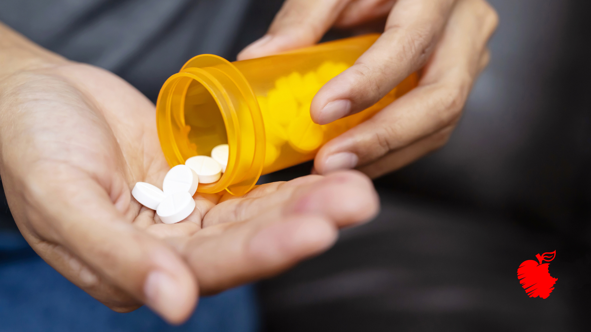 A person is pouring pills from a bottle into their hand.