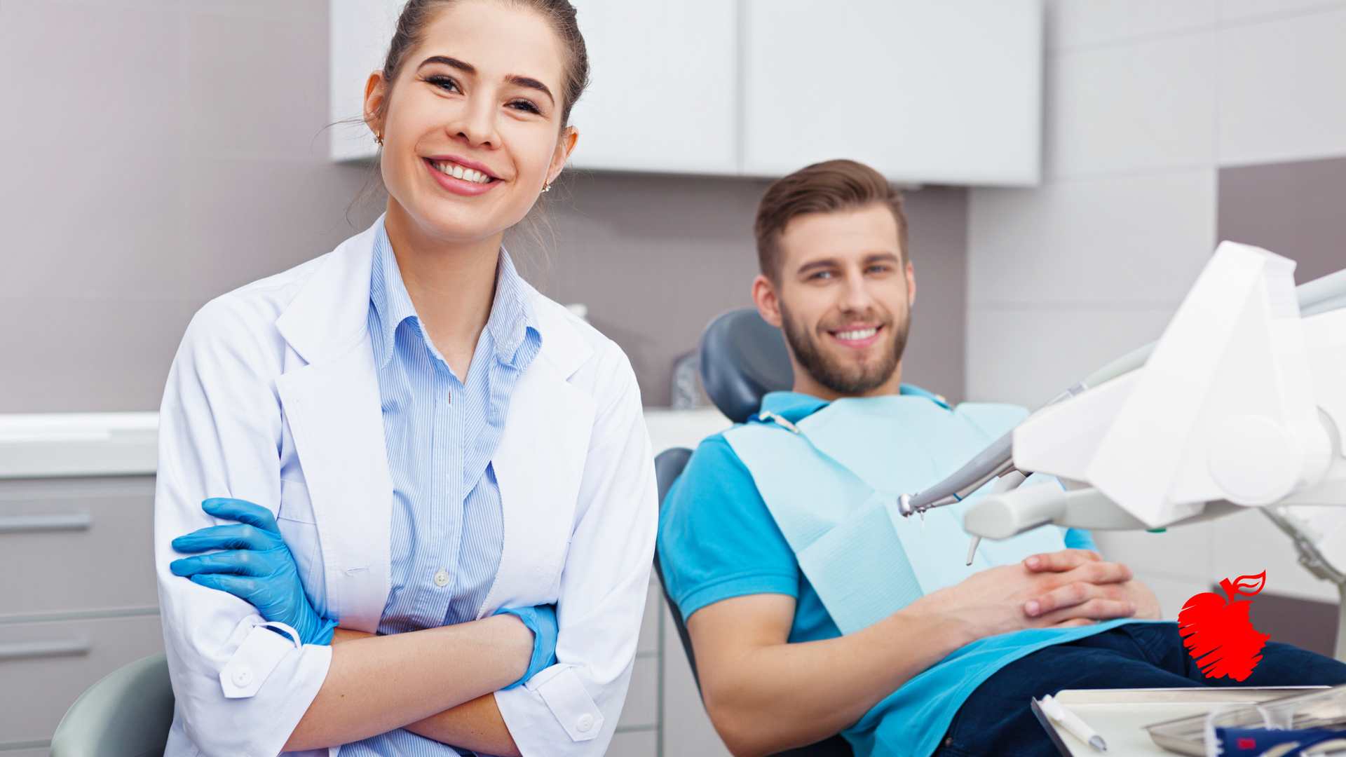 A woman is standing next to a man in a dental chair.