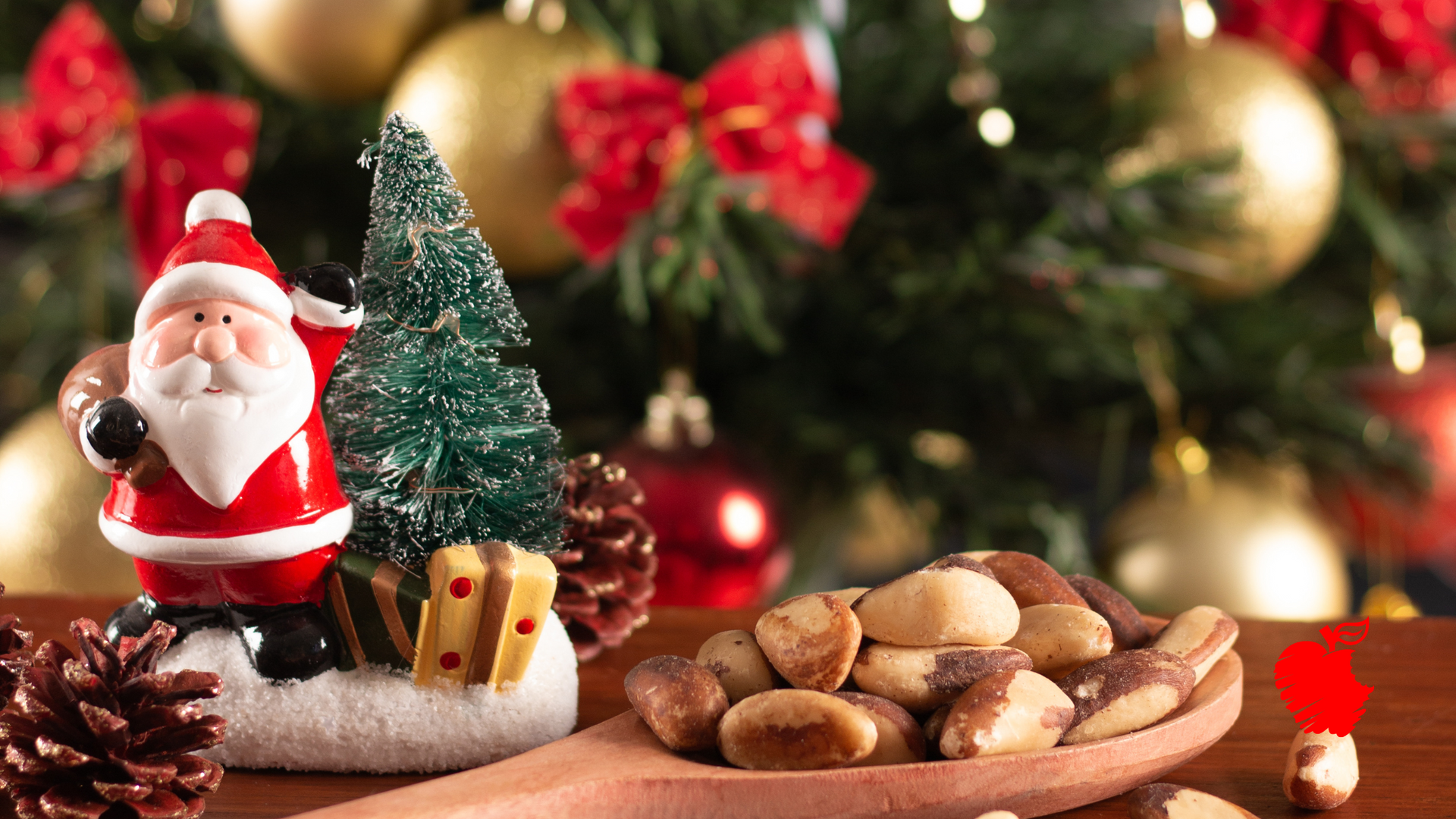 A wooden spoon filled with nuts next to a santa figurine and a christmas tree.