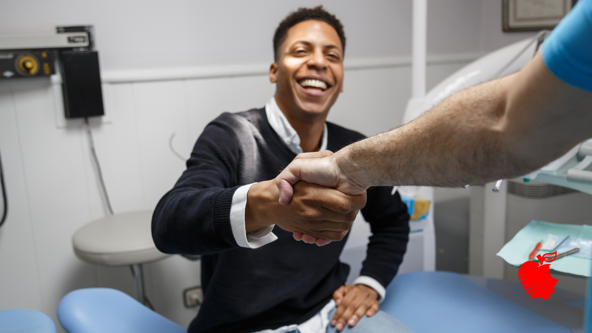 A man is shaking hands with a dentist in a dental office.