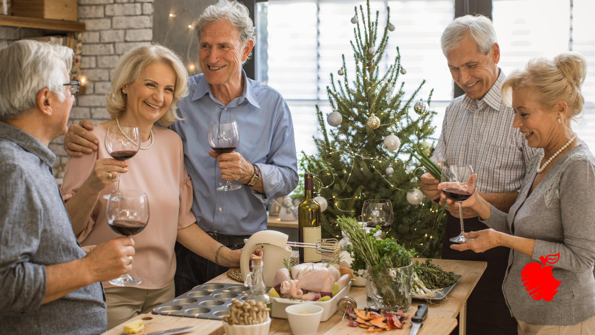 A group of elderly people are standing around a table holding wine glasses in front of a christmas tree.