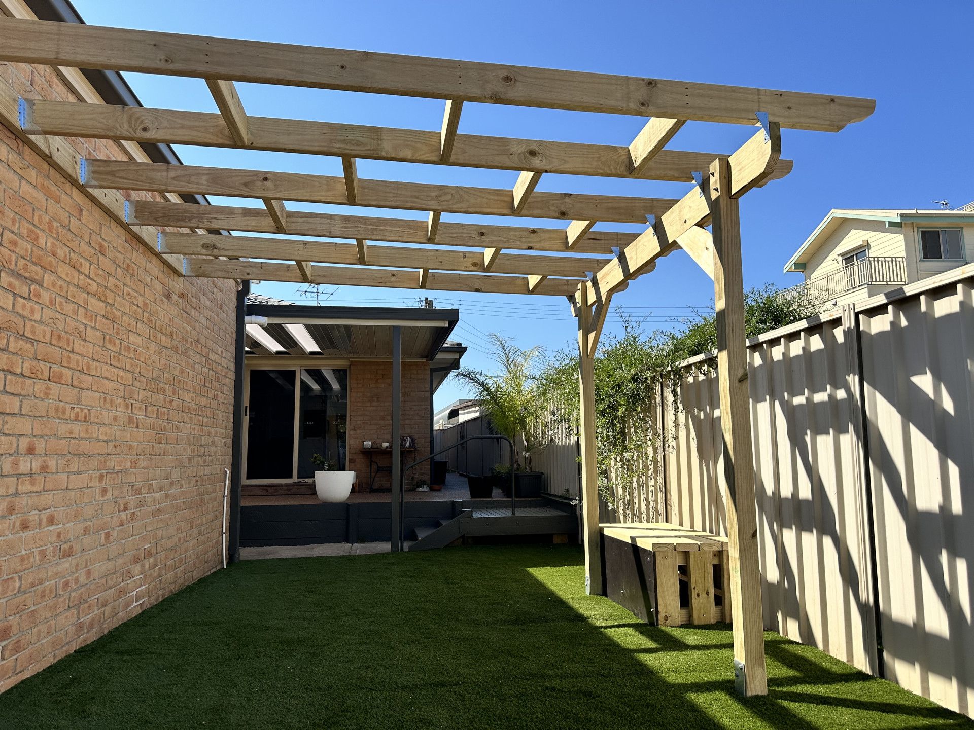 A Pergola With A Clear Roof And A Blue Sky In The Background — Newcastle Patio Covers In Wallsend, NSW