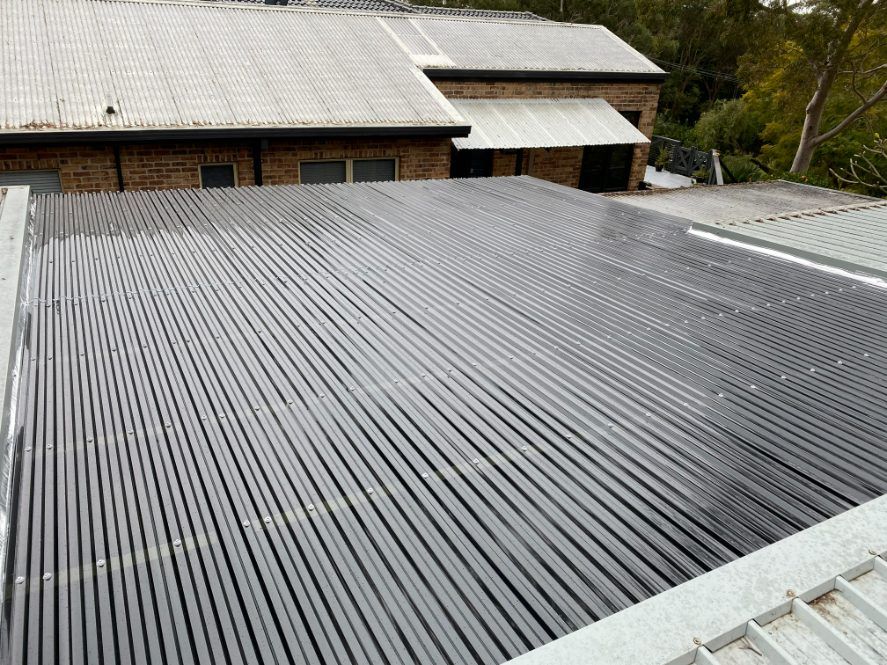 The Roof Of A Building With A Black Roof And A White Roof — Newcastle Patio Covers In Wallsend, NSW