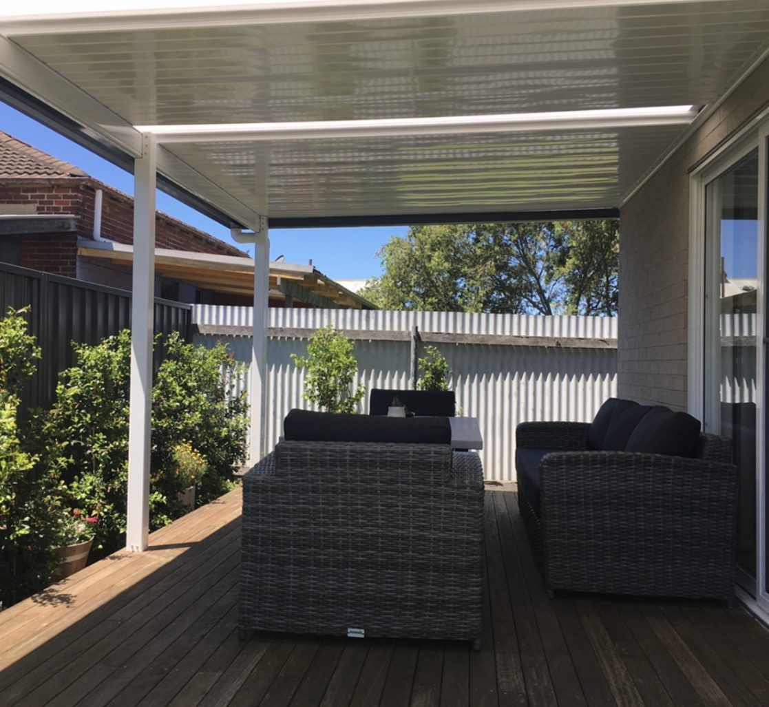 A Patio With Wicker Furniture And A White Roof — Newcastle Patio Covers In Wallsend, NSW