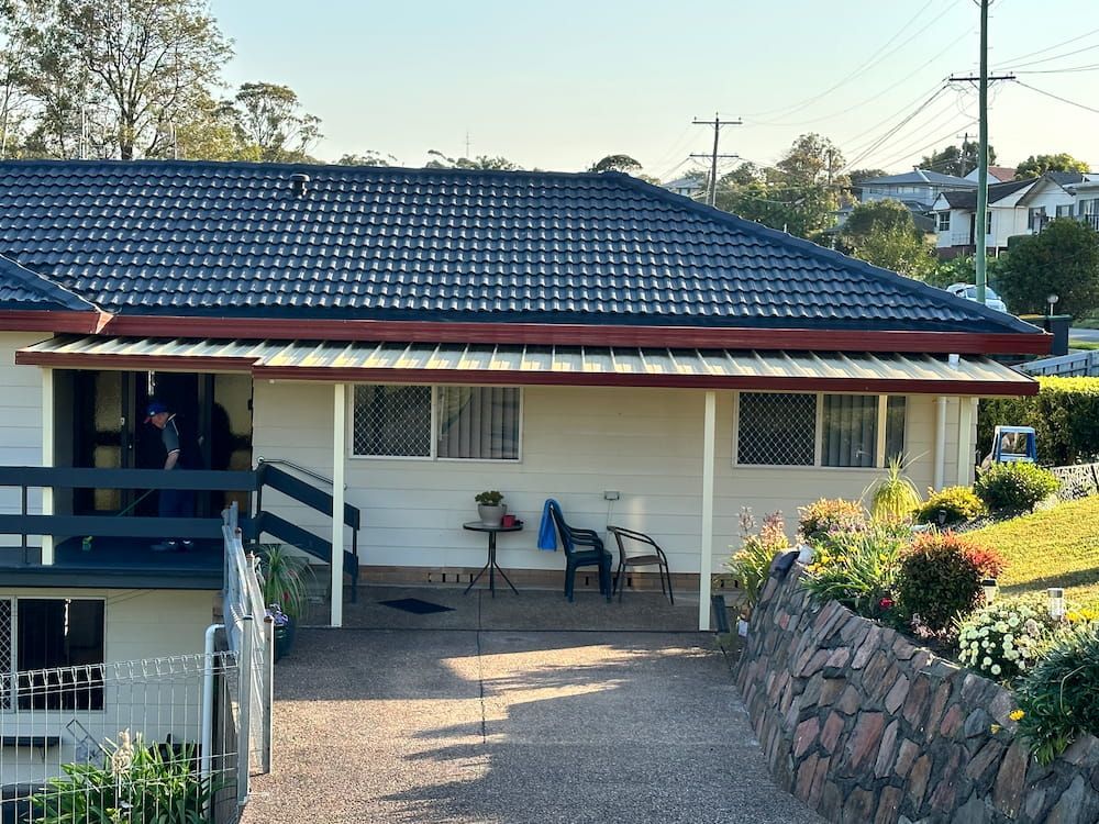 A White House With A Blue Roof And A Porch — Newcastle Patio Covers In Wallsend, NSW