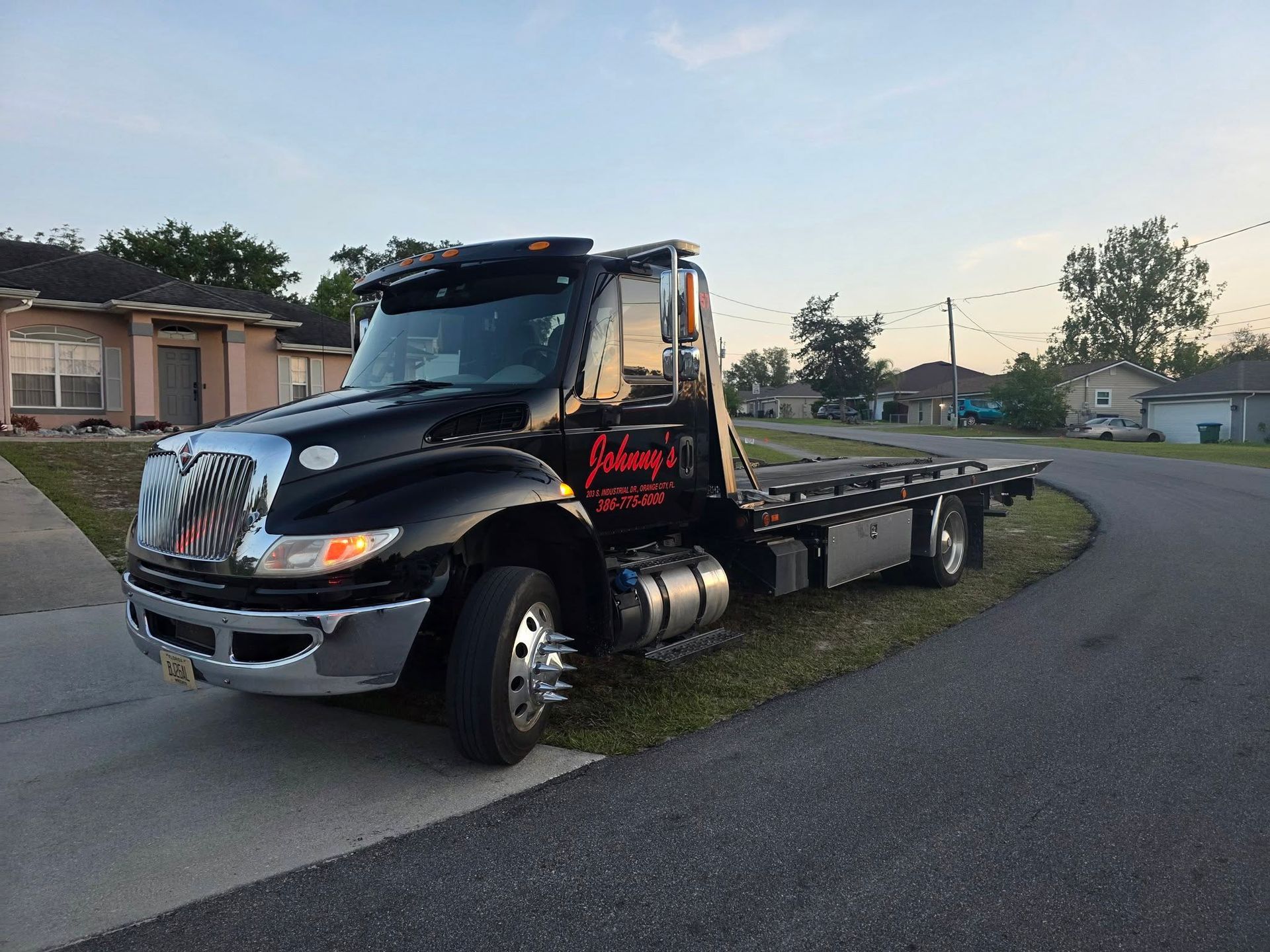 Black tow truck parked on a residential street.