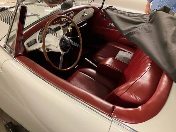 A white car with red seats and a steering wheel