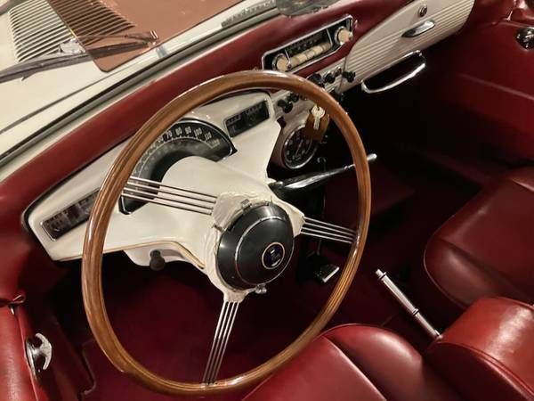A car with a wooden steering wheel and red seats