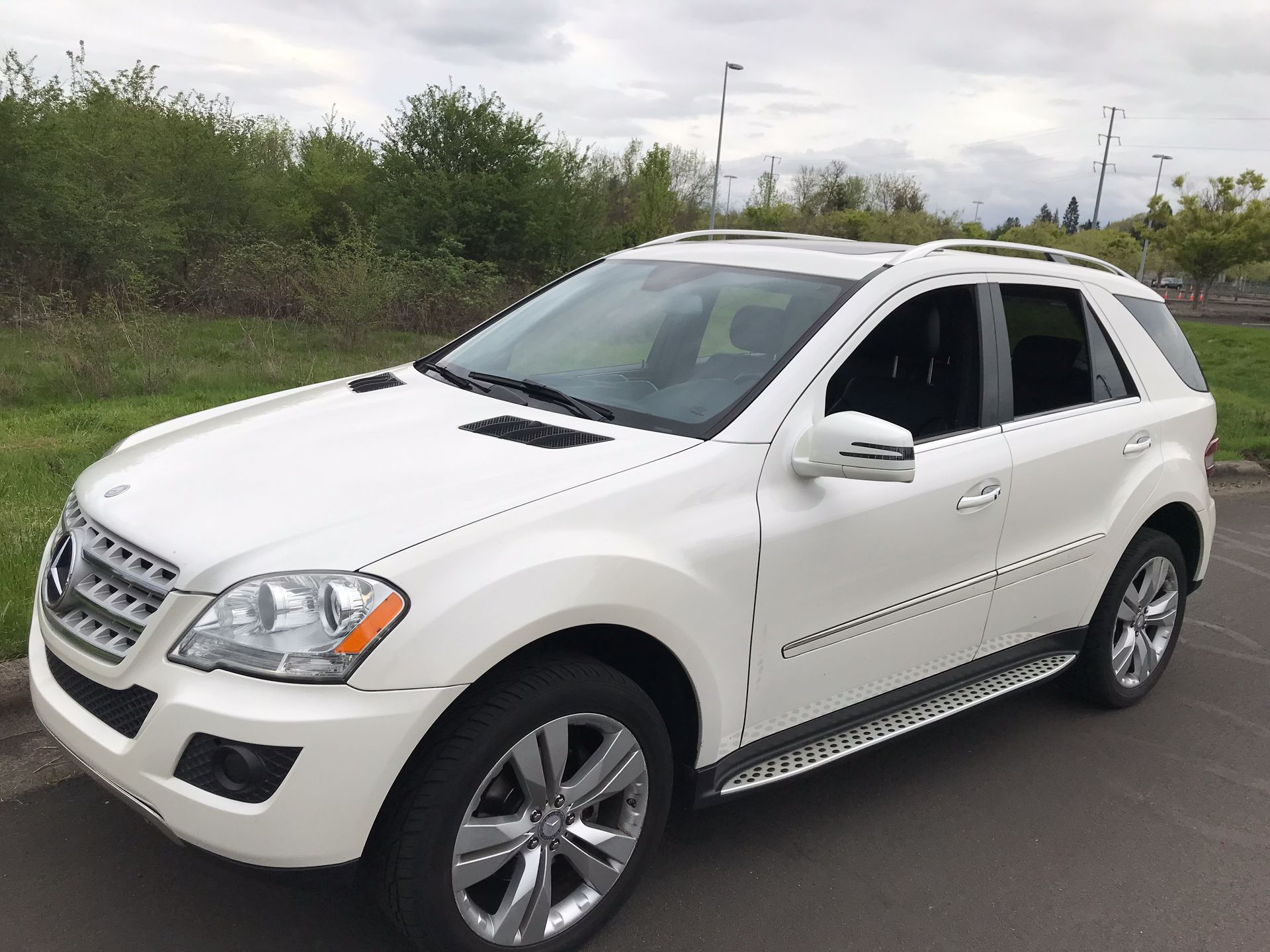 A white mercedes benz suv is parked in a parking lot