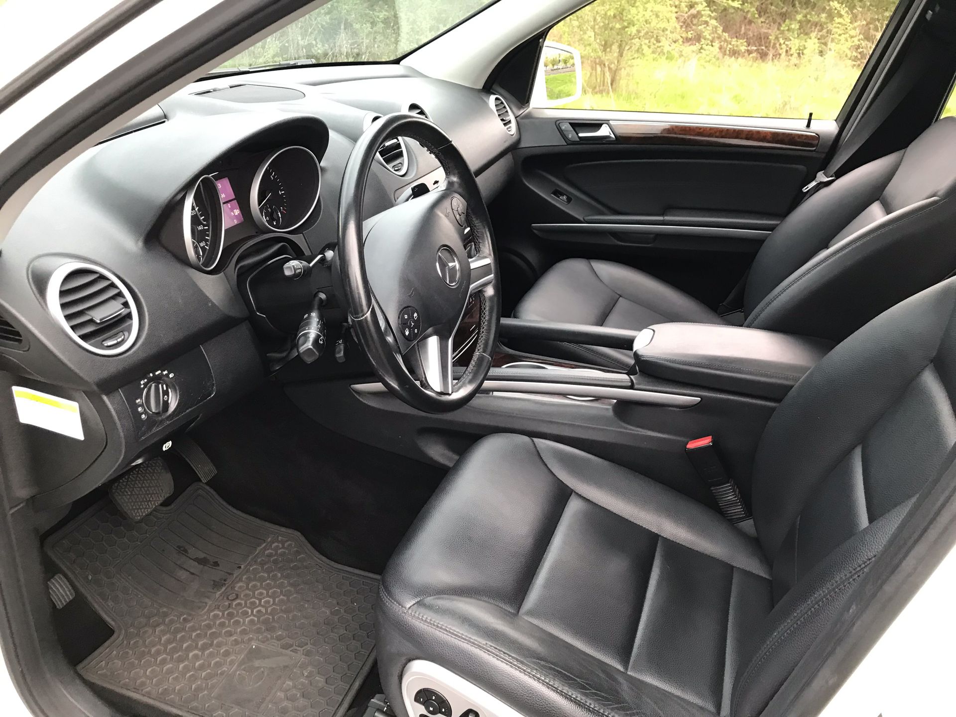 The interior of a white car with black leather seats and a steering wheel.