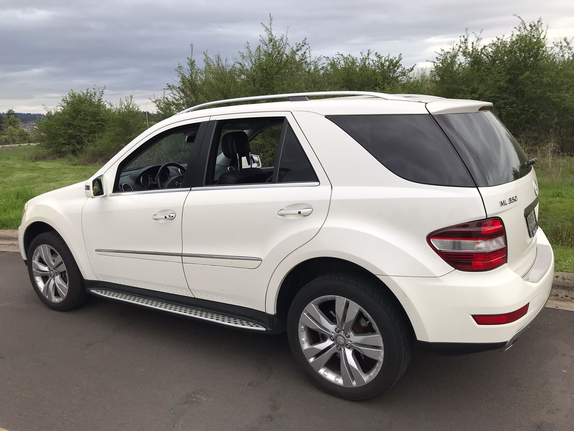 A white suv is parked on the side of the road.