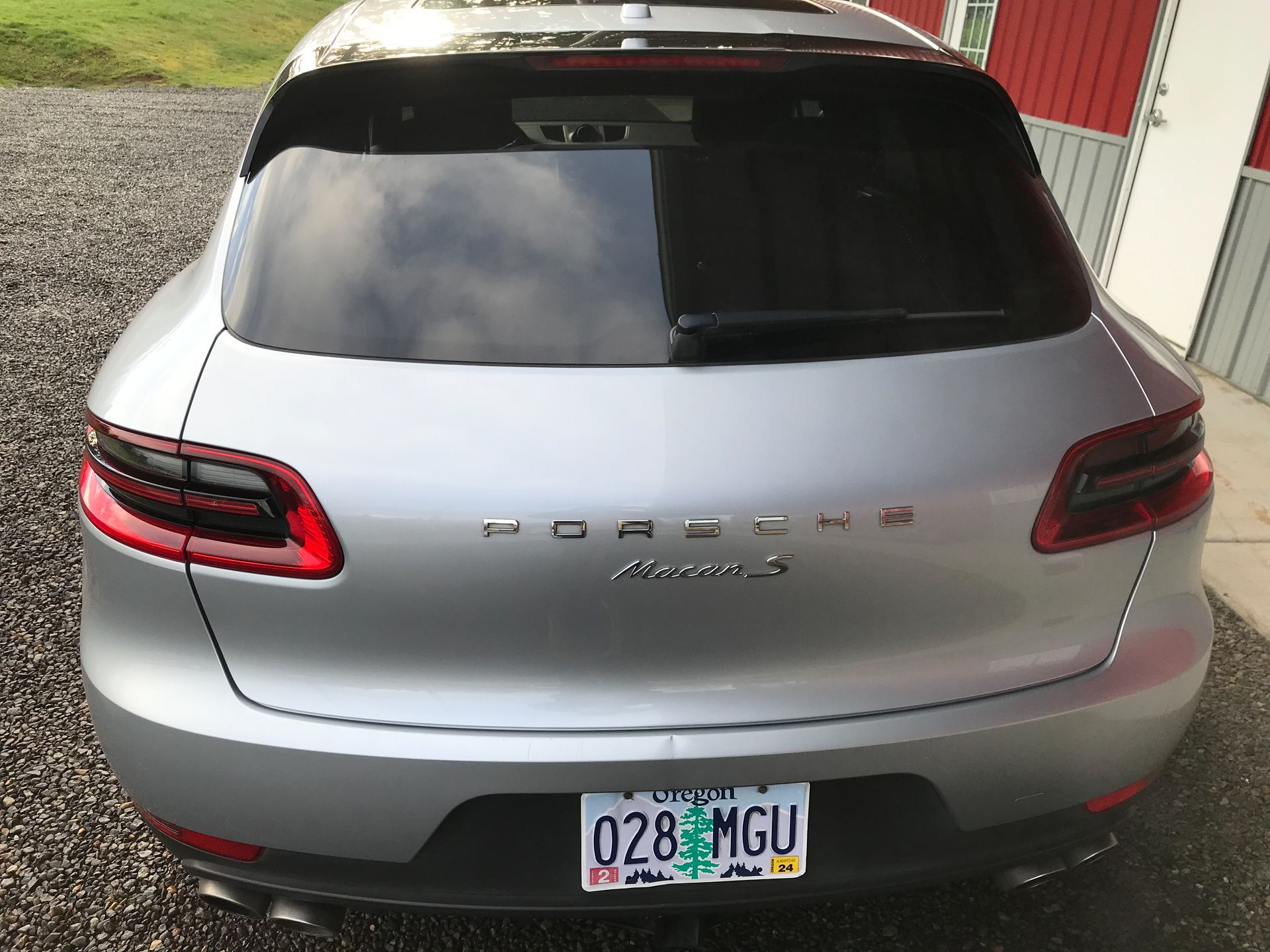 A silver porsche with a license plate that says 028ngu