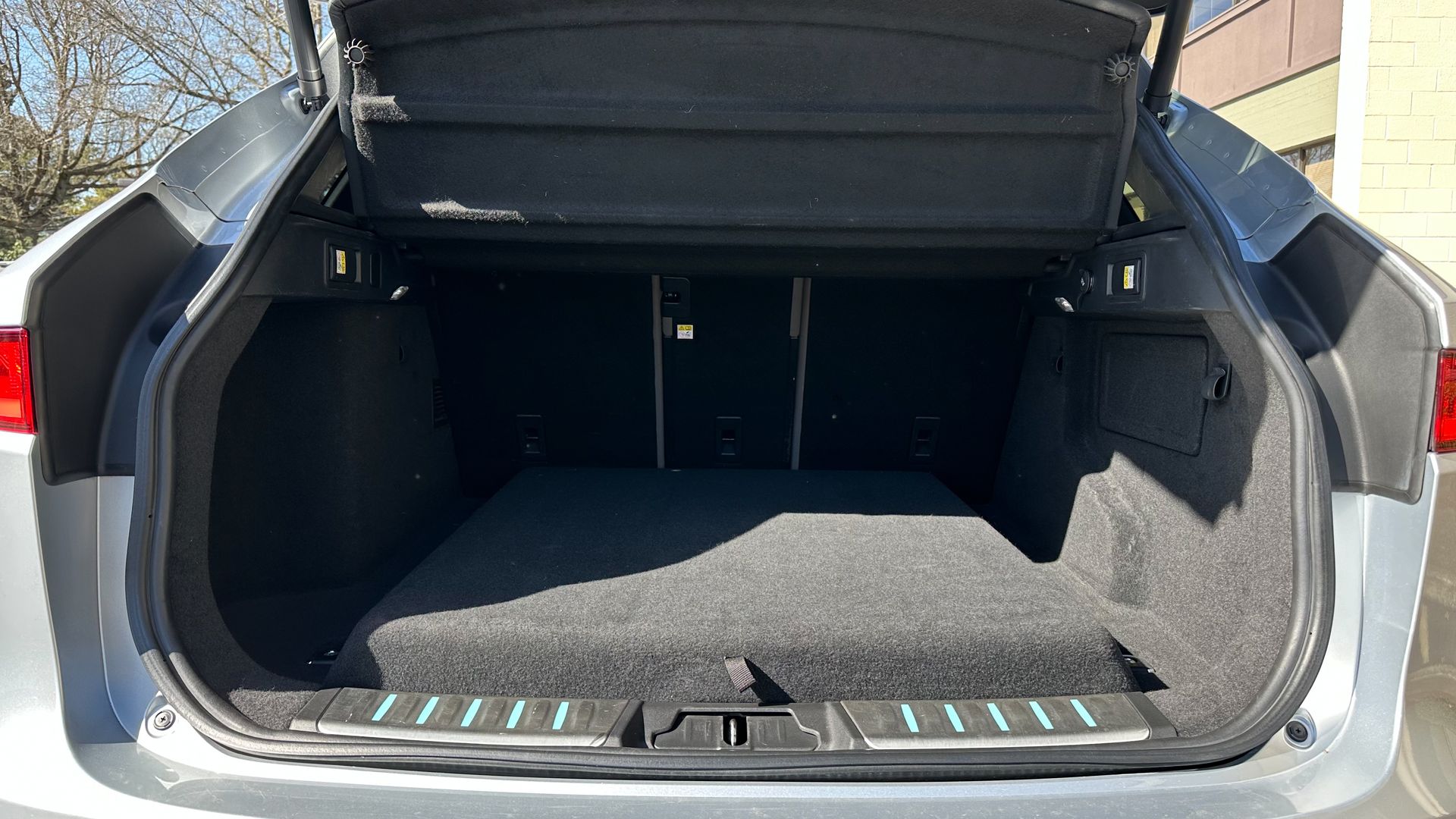 The trunk of a silver car with the trunk lid open