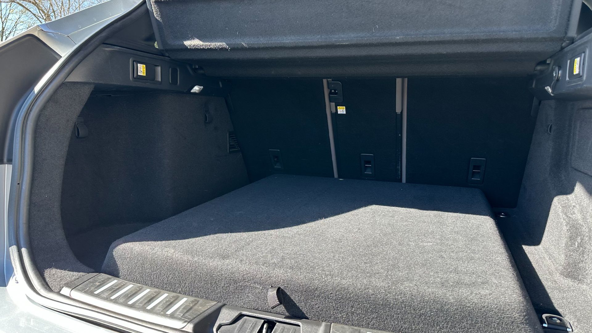 The trunk of a car is open and empty.