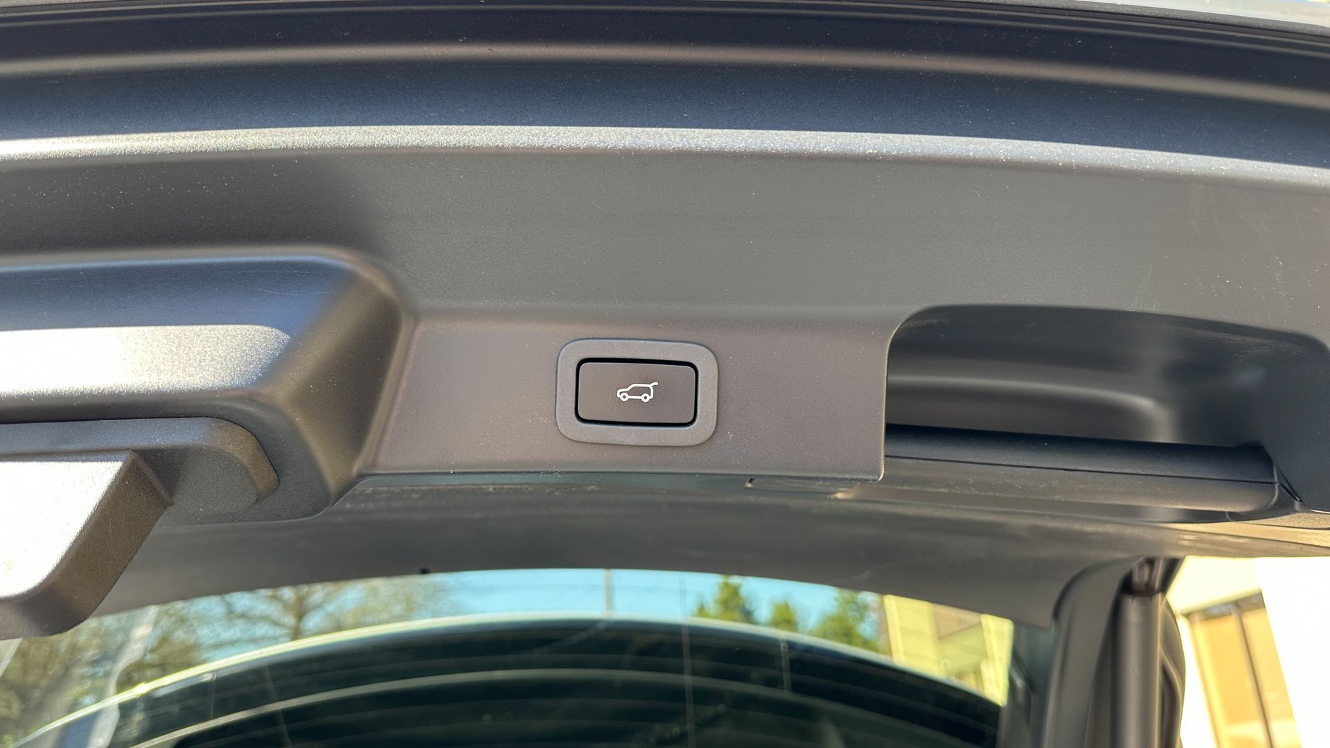 A close up of a car trunk with a button on it.