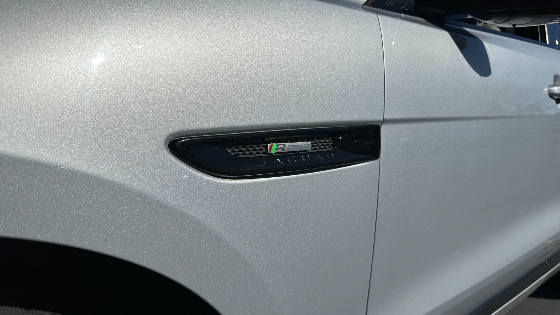 A close up of the side of a silver car