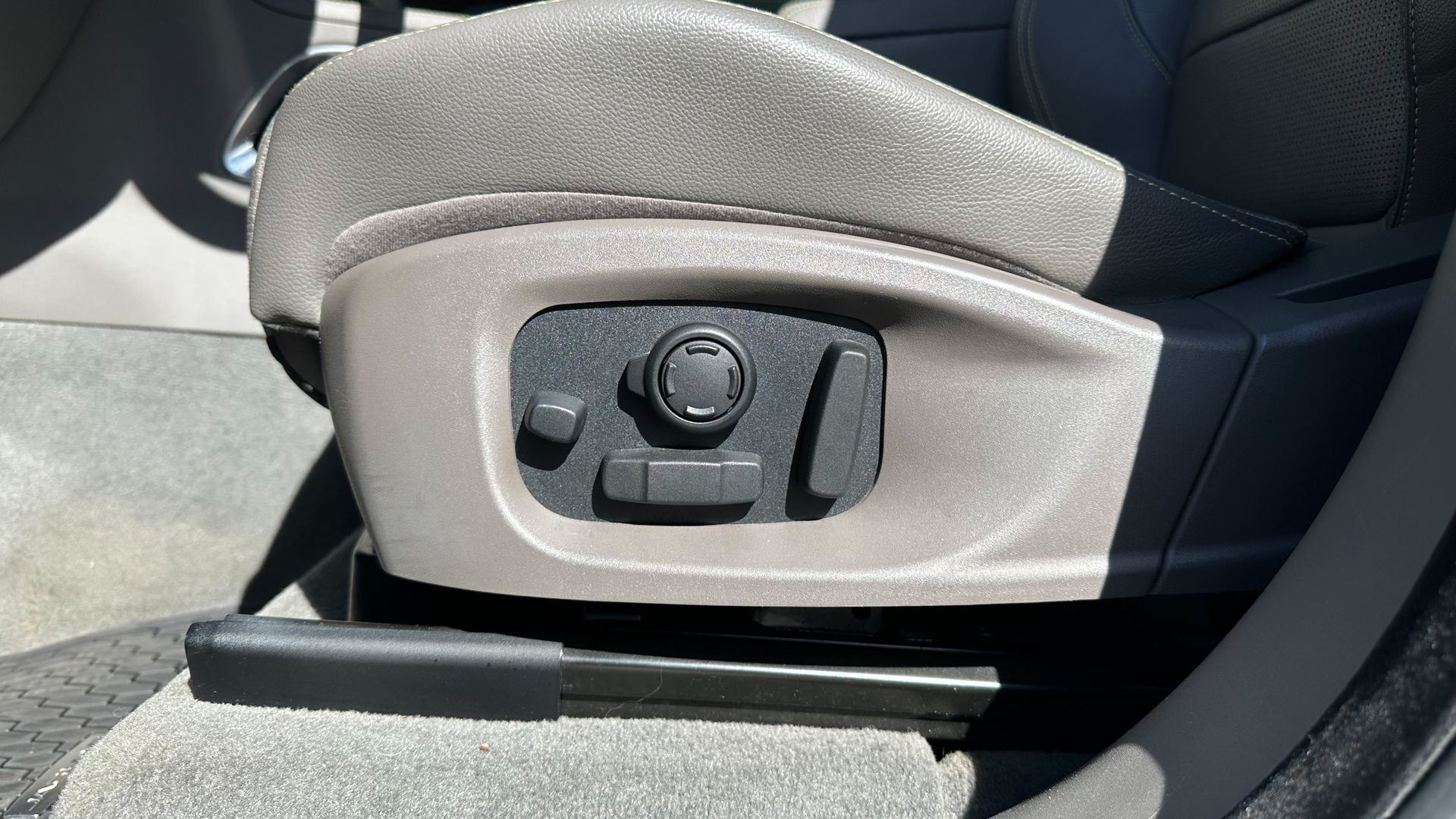 A close up of a car seat with a button on it.