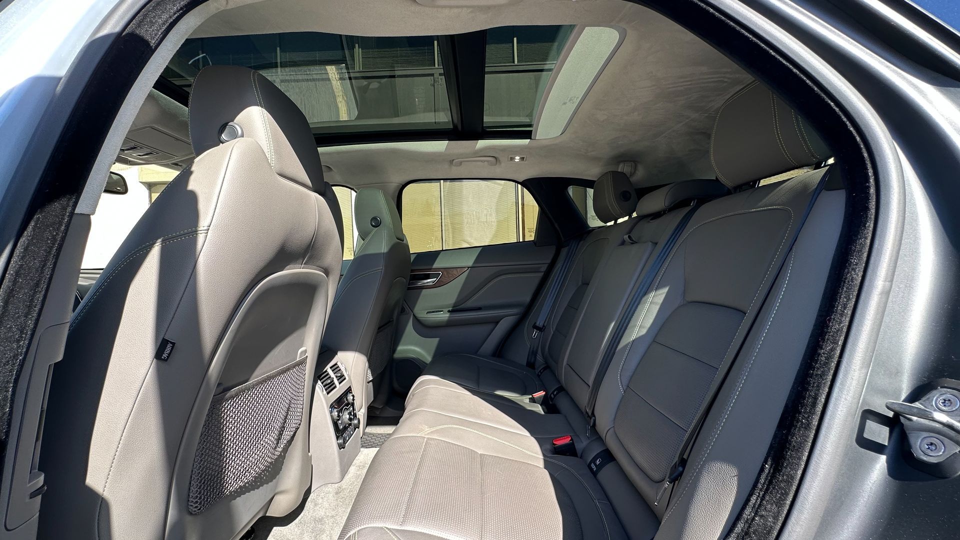 The back seat of a car with a sunroof.