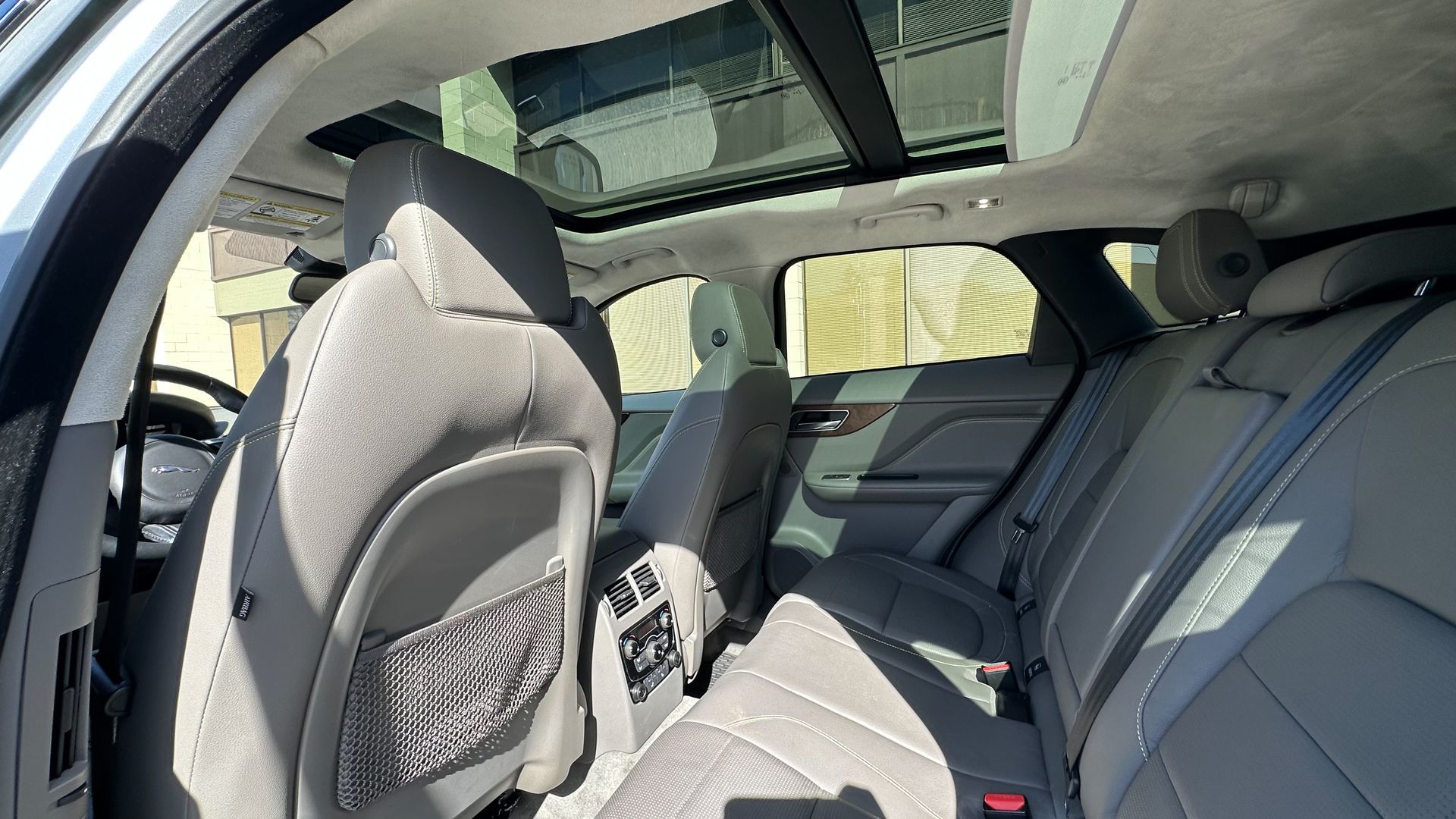 The back seat of a car with a sunroof.