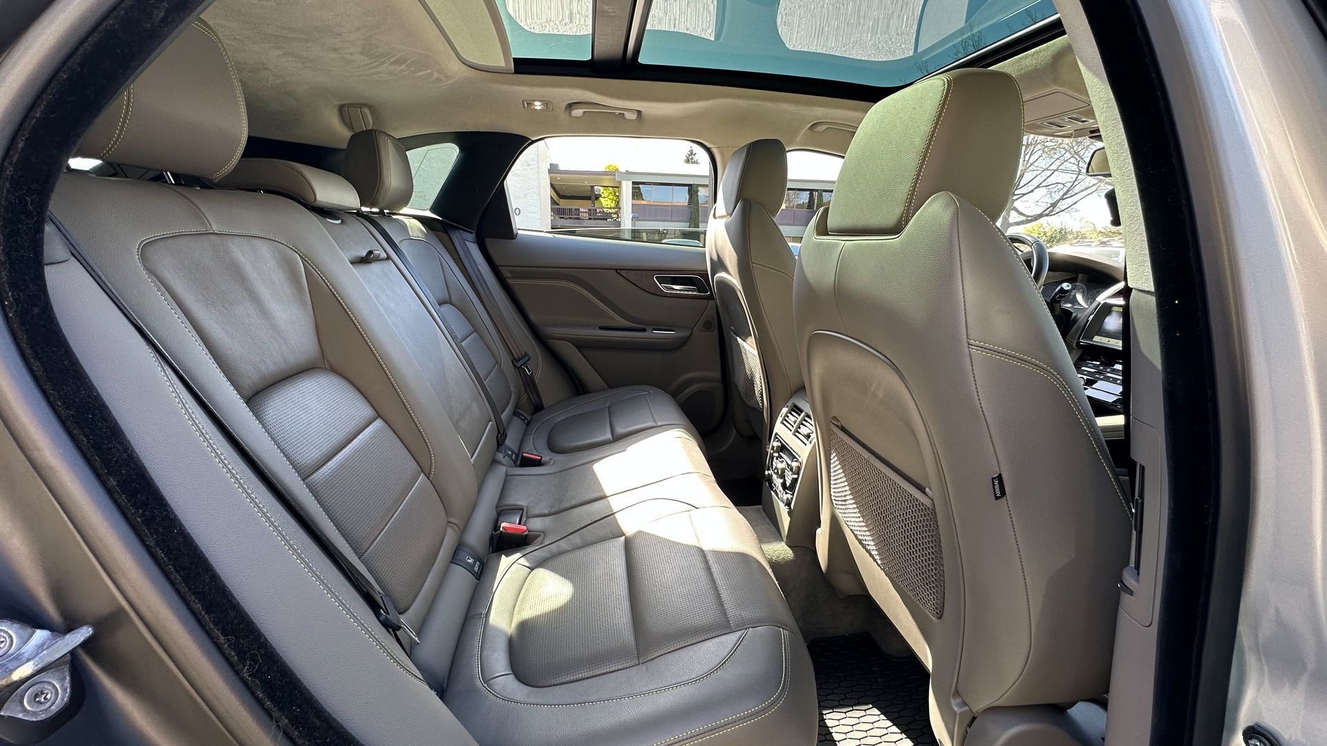 The back seat of a car with a sunroof.