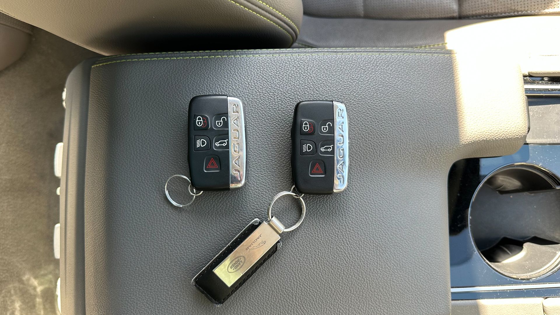 Two remote keys are sitting on a table in a car.