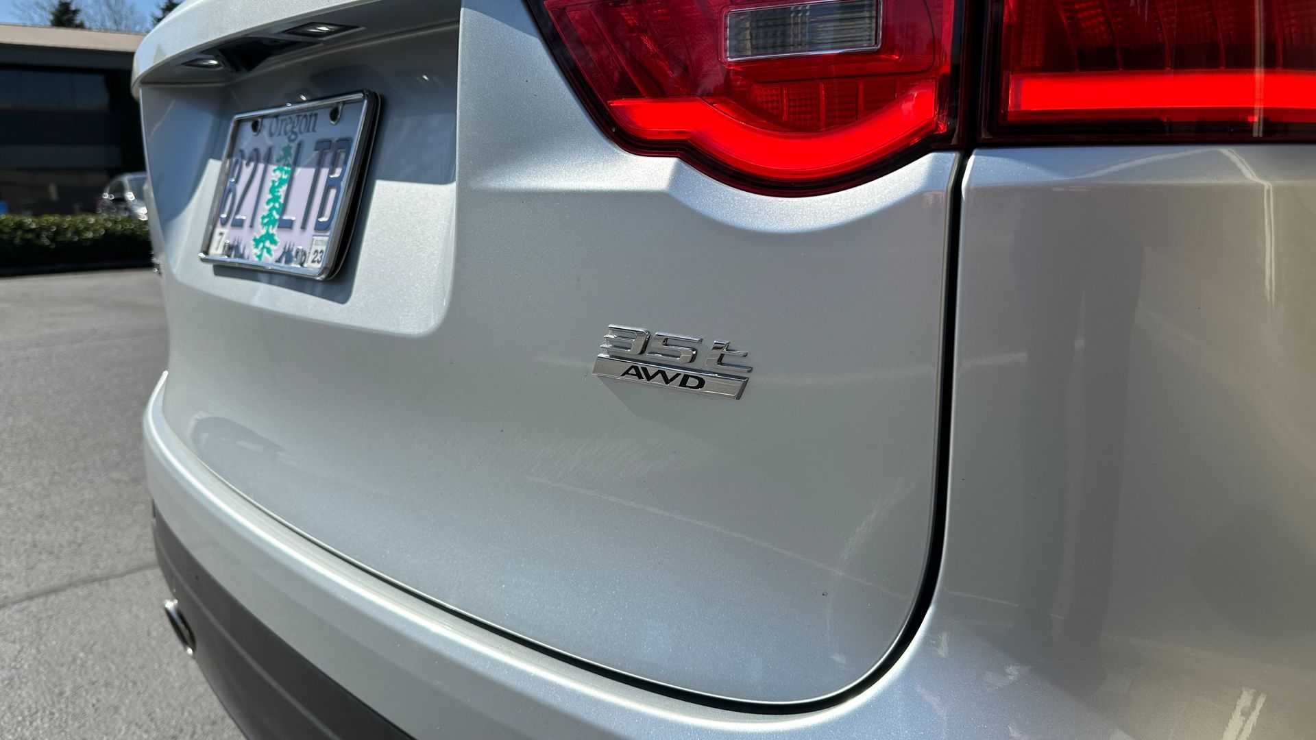 A close up of the back of a silver car with a license plate that says washington