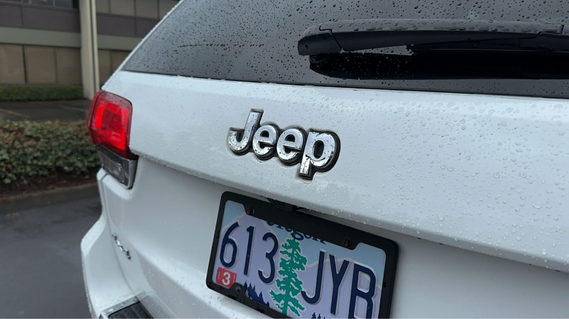 The back of a white jeep with a license plate that says 613 jyr.