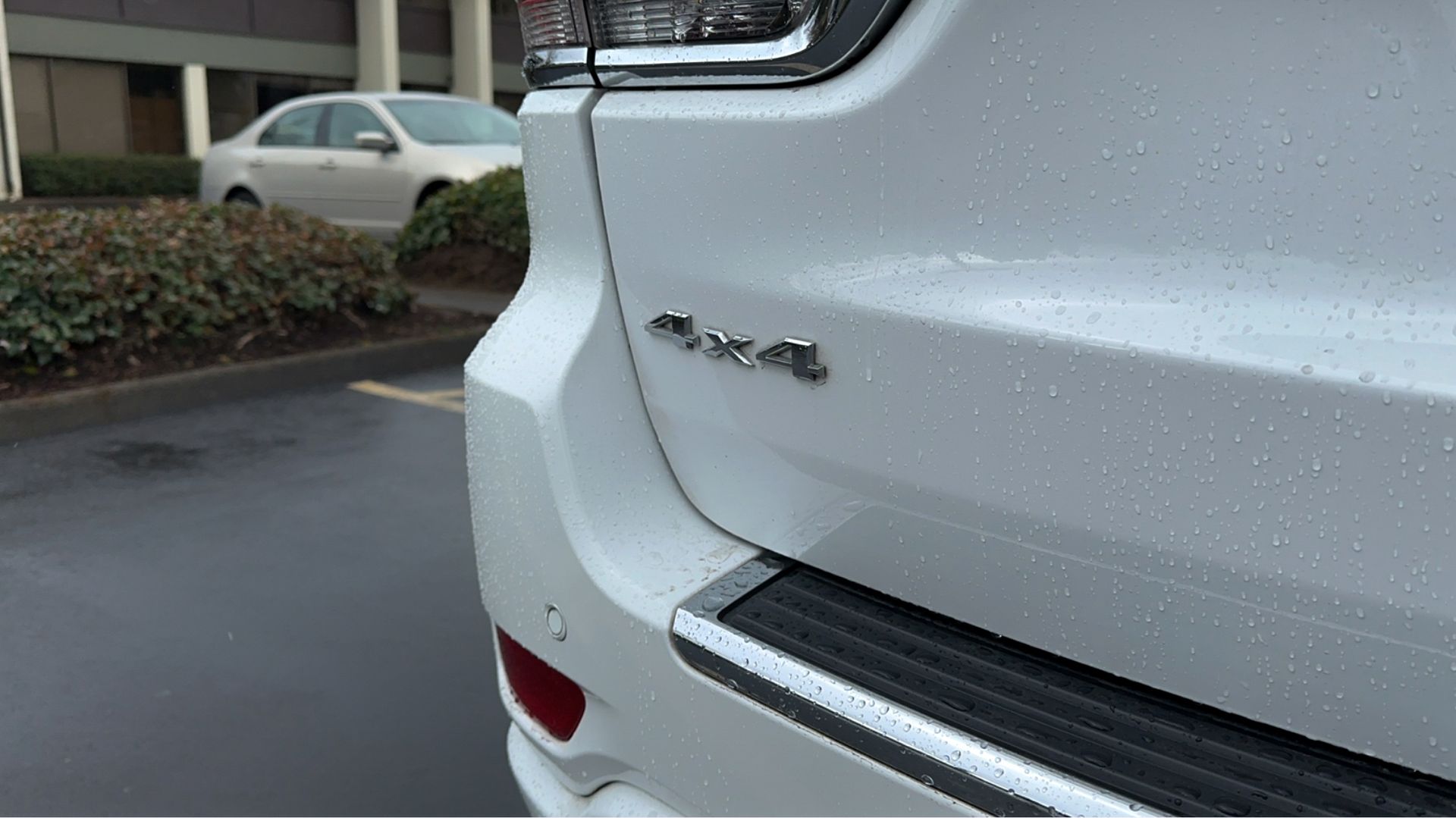 A white jeep grand cherokee is parked in a parking lot.