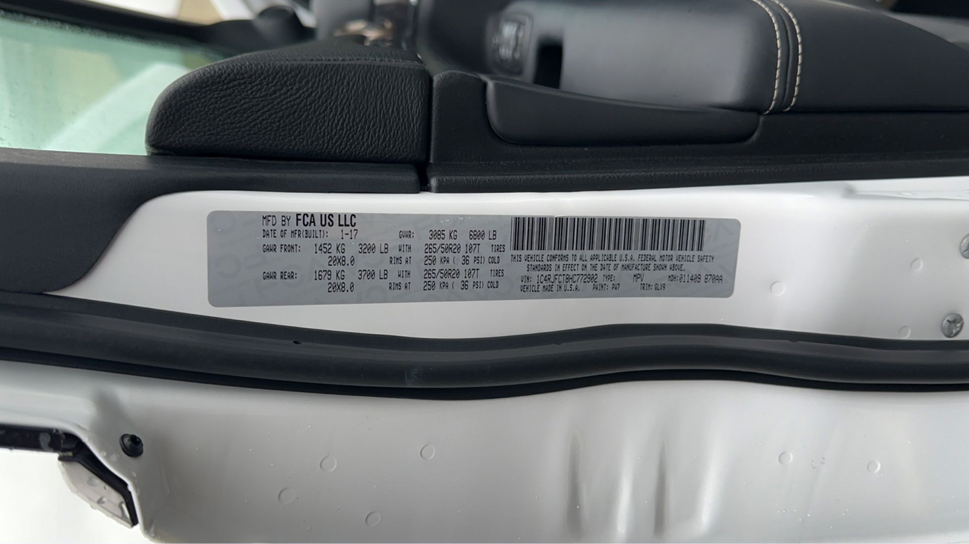 A close up of a white car with a sticker on the side of it.