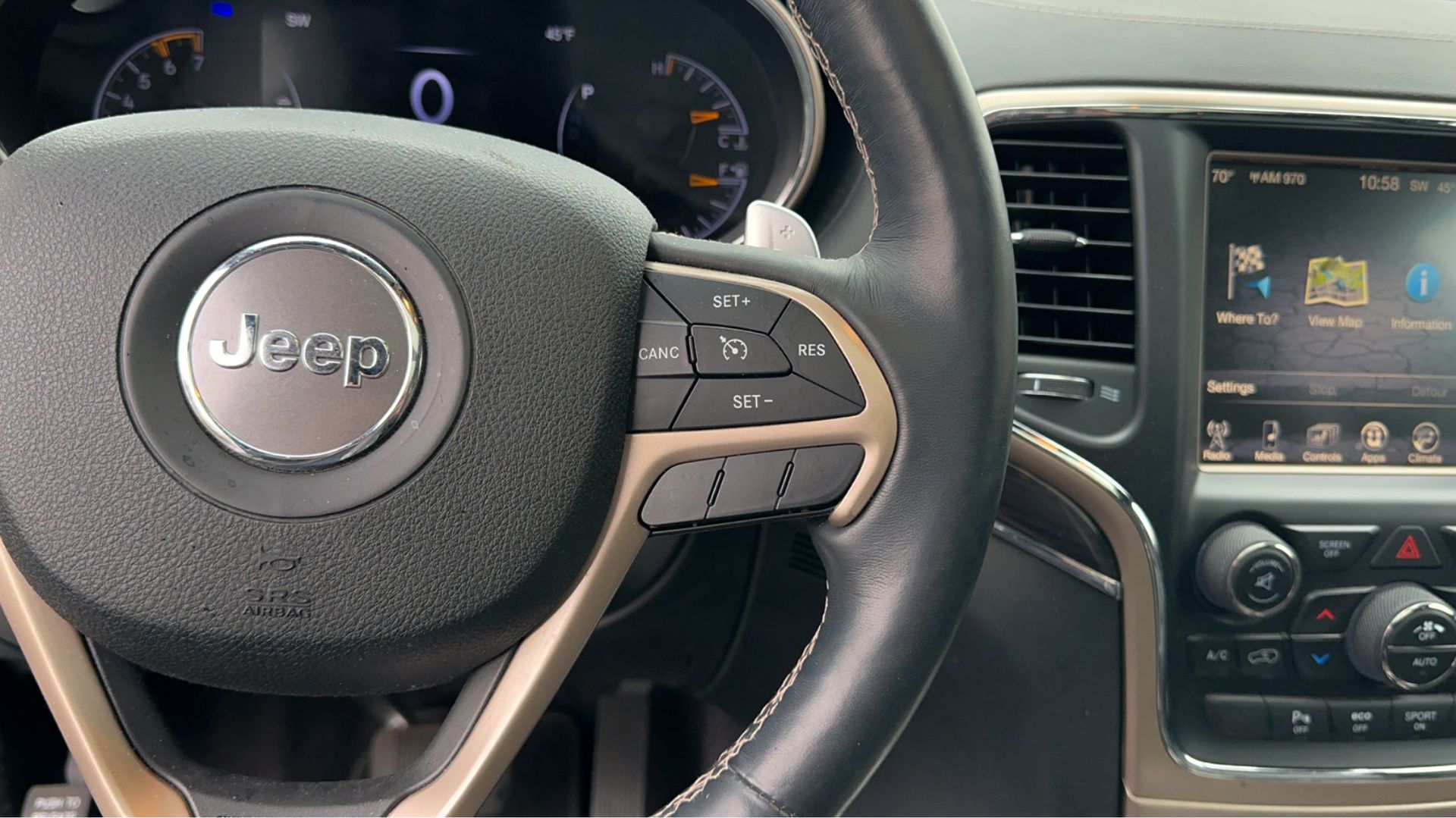 A close up of a jeep steering wheel and dashboard