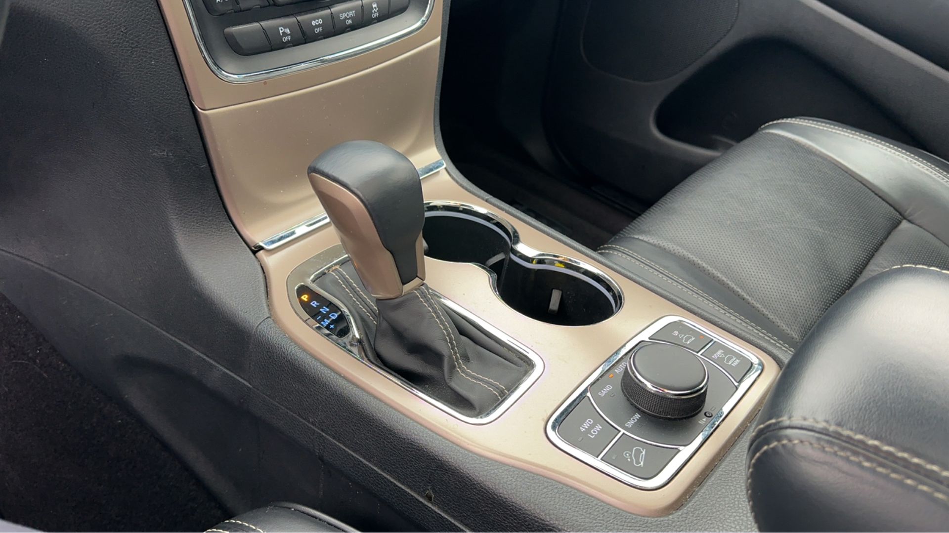 A close up of a car 's center console with a cup holder