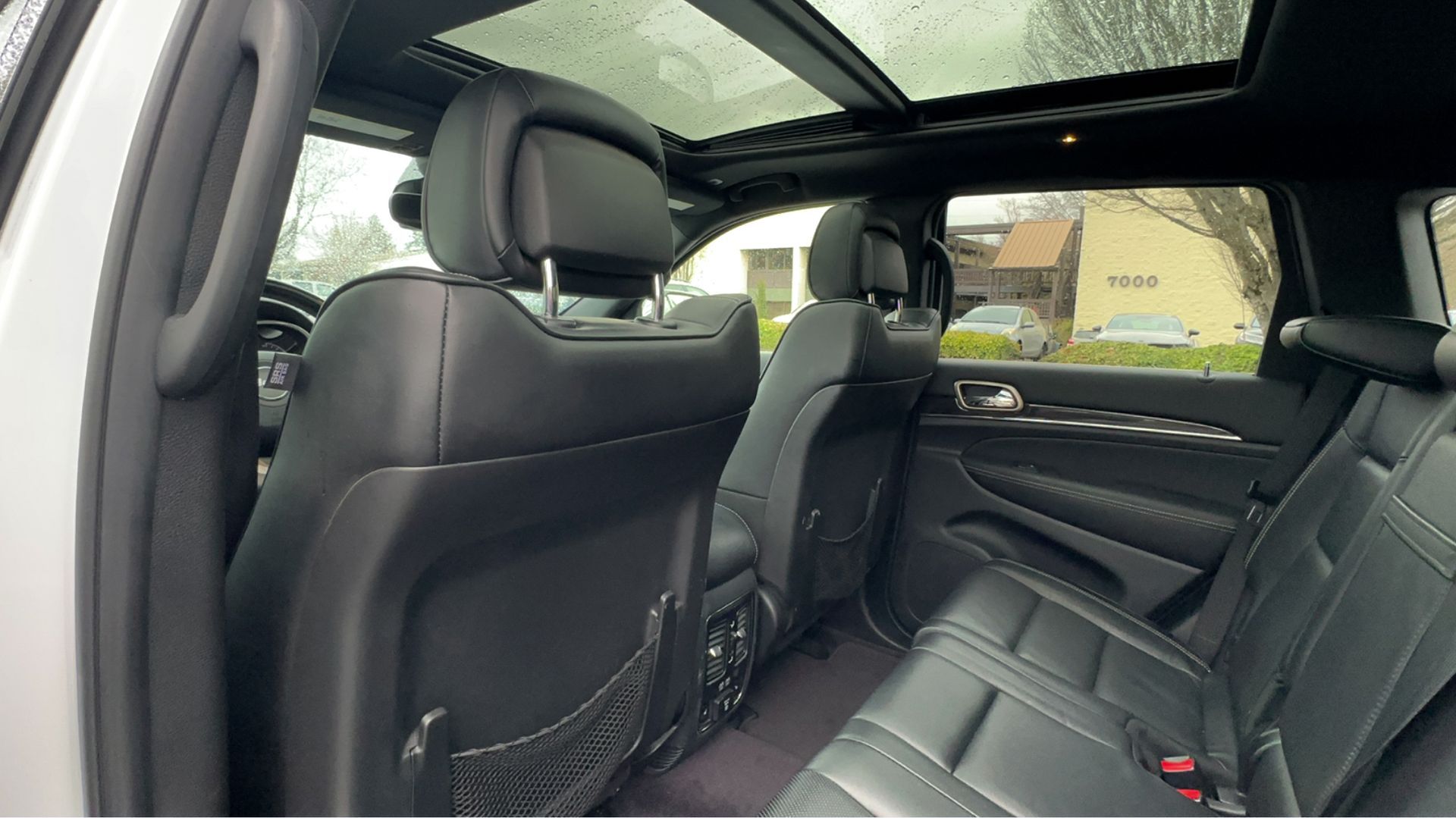 The back seat of a jeep grand cherokee with a sunroof.