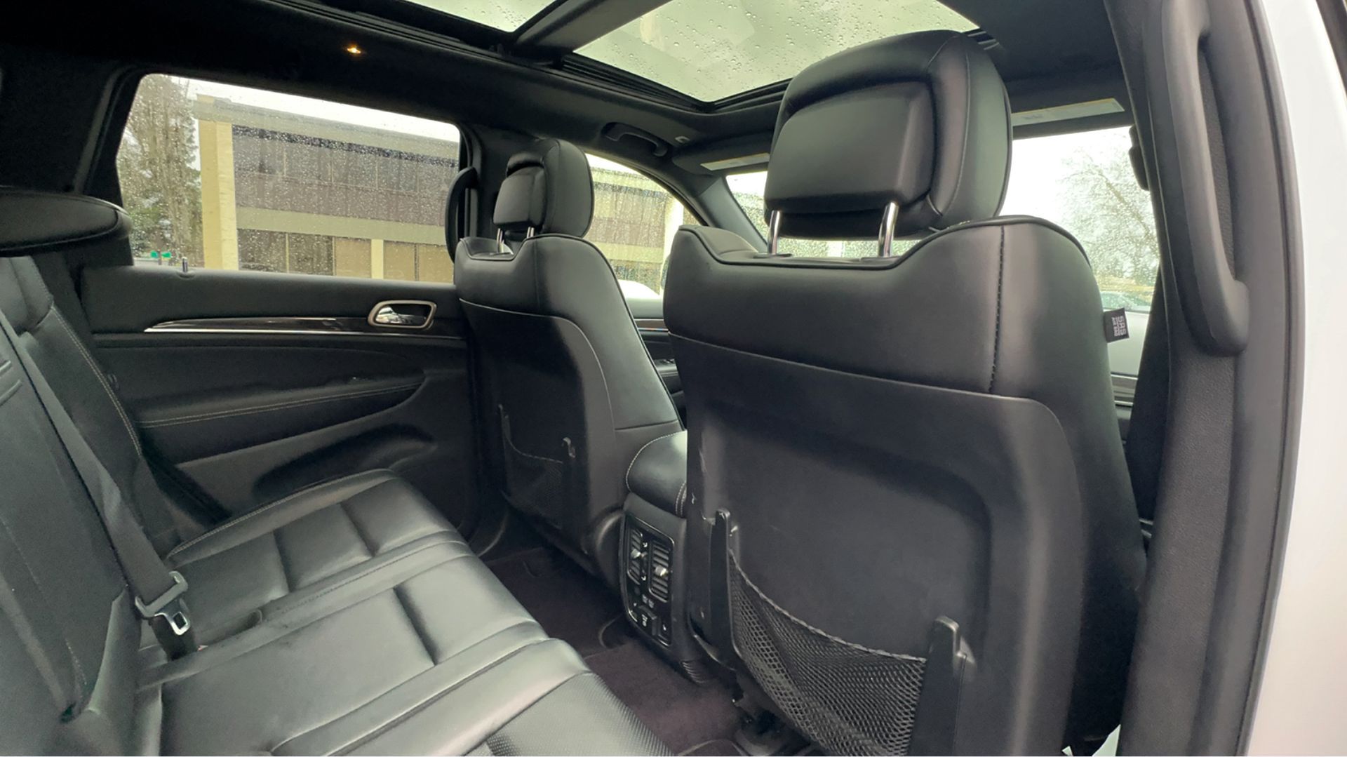 The back seat of a jeep grand cherokee with a sunroof.