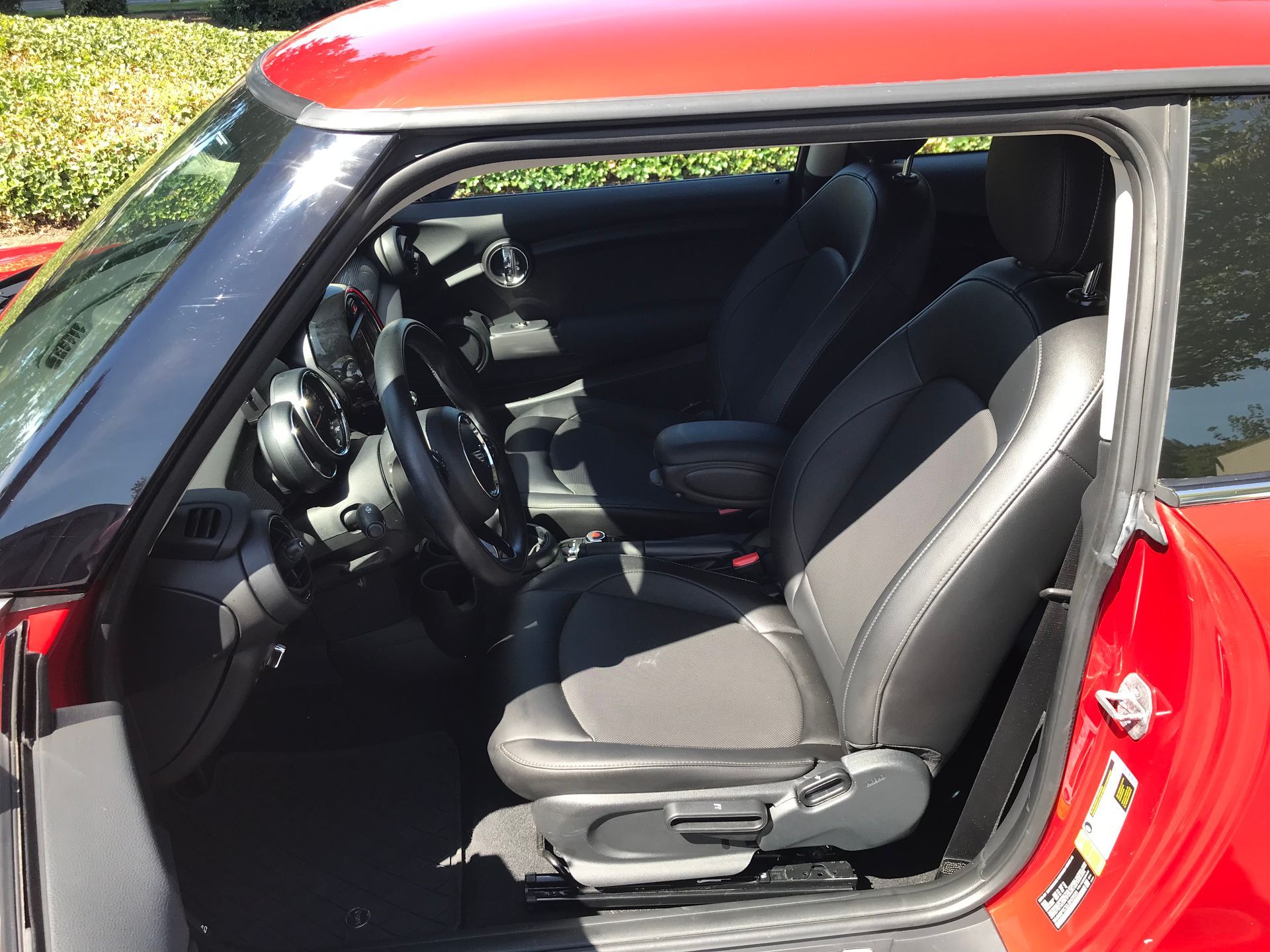 The inside of a red mini cooper with the door open.
