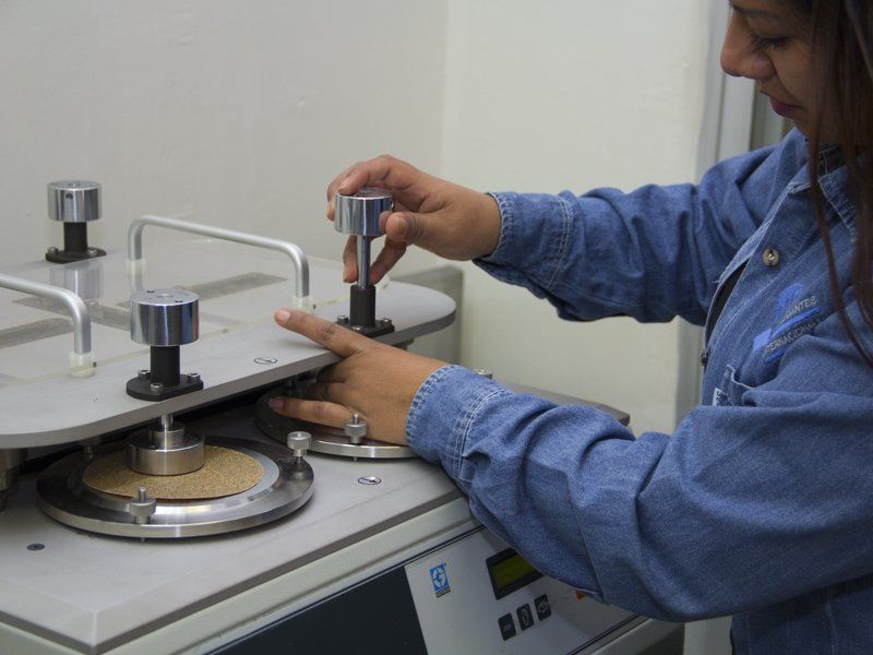 Una mujer con una camisa azul está trabajando en una máquina