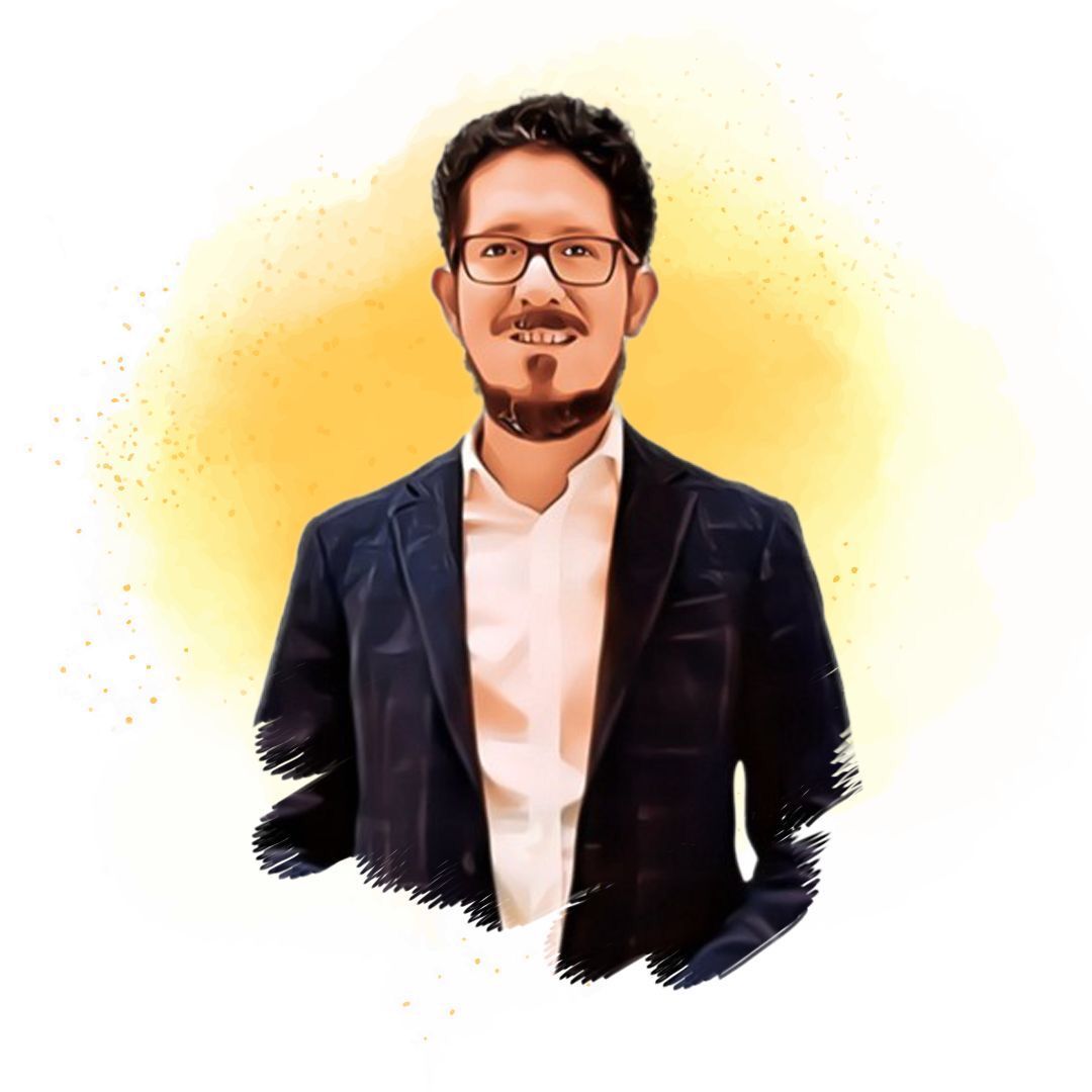 Un hombre con barba y gafas viste traje y camisa blanca.