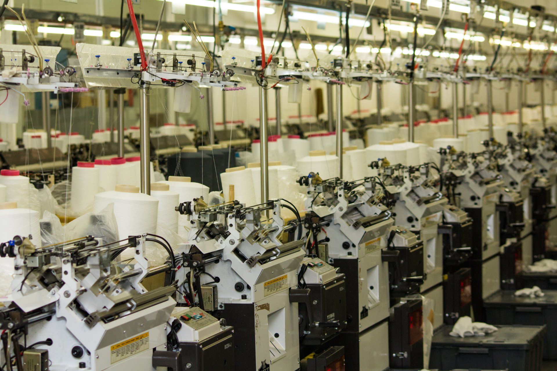 Una fila de máquinas para fabricar calcetines en una fábrica.