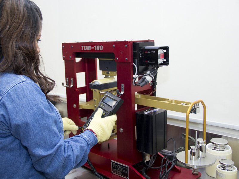 Una mujer está trabajando en una máquina que dice tdh-190