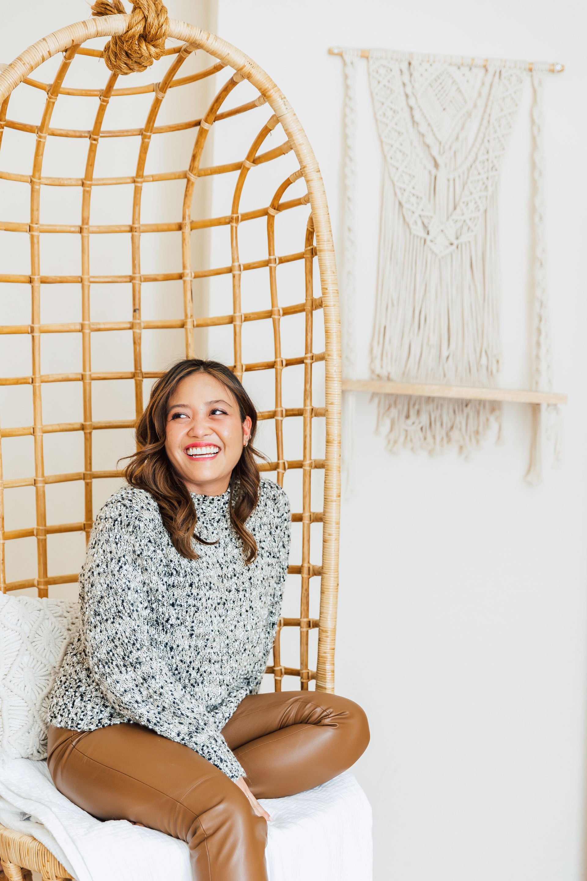 woman sitting on wicker chair smiling