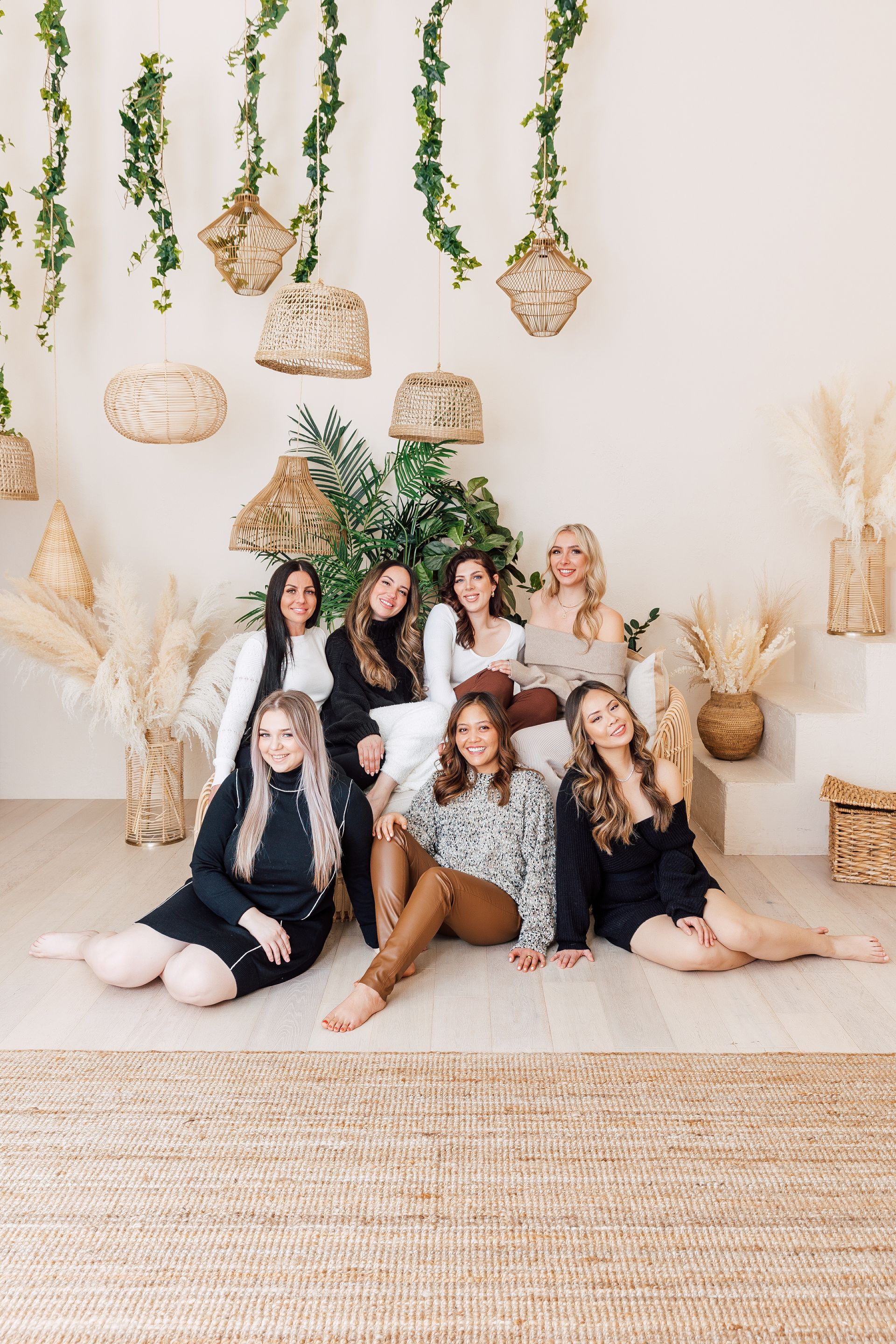 A group of women are sitting on the floor posing for a picture.