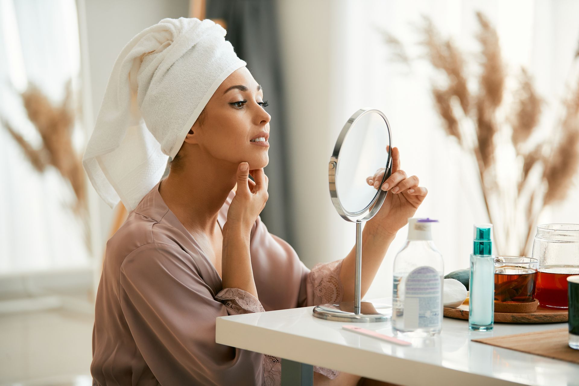 young beautiful woman looking at her face in mirror