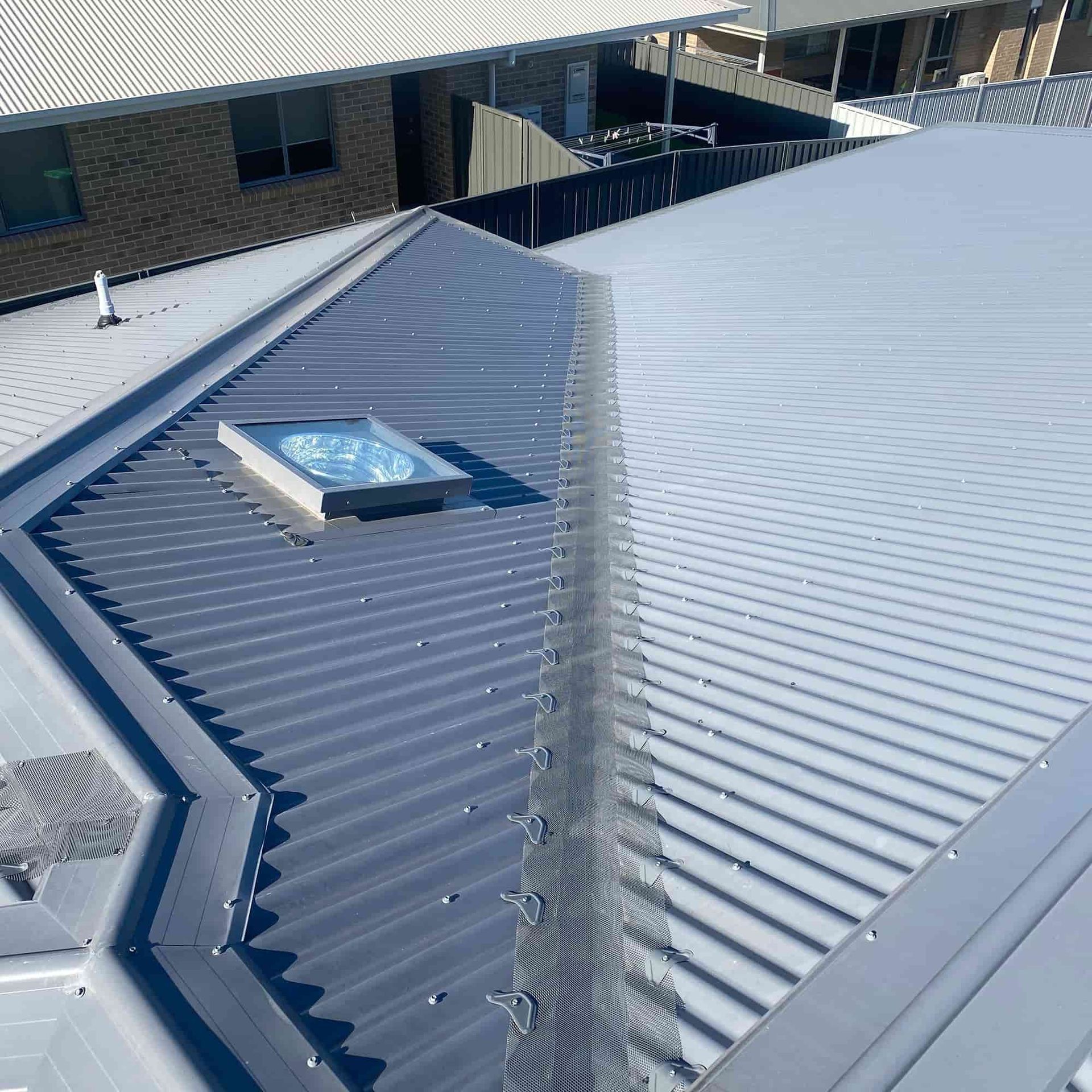 Metal roof with skylight, various shades of gray.