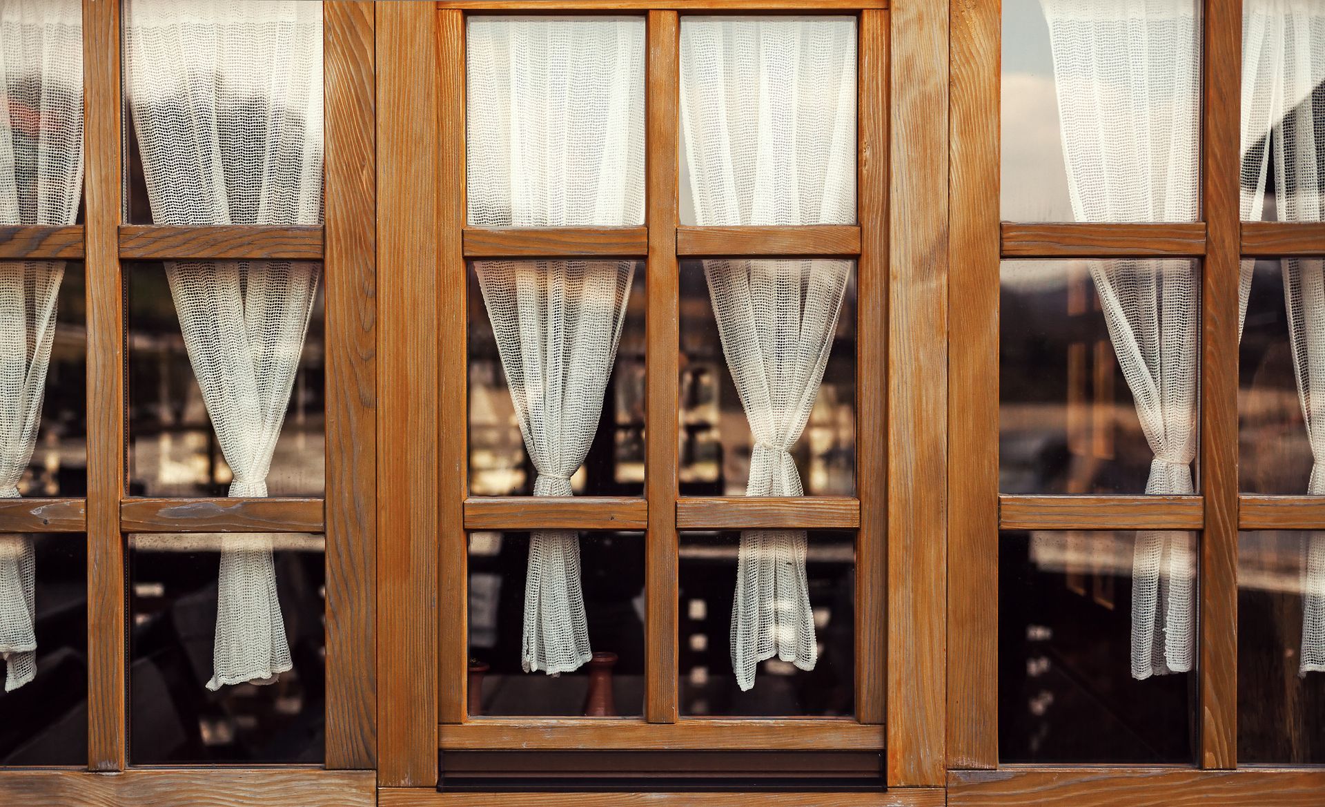 Wooden window with lace curtains.