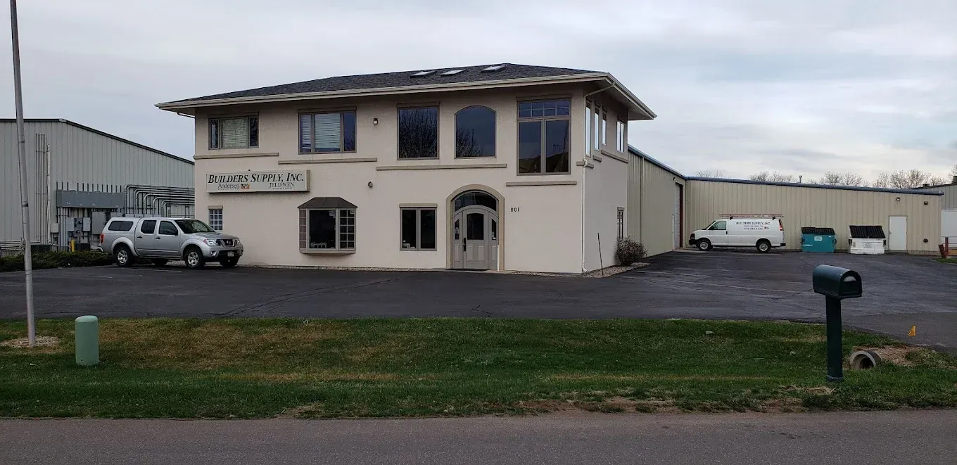 Assorted doors and windows displayed in a store, showcasing different styles and wood tones.