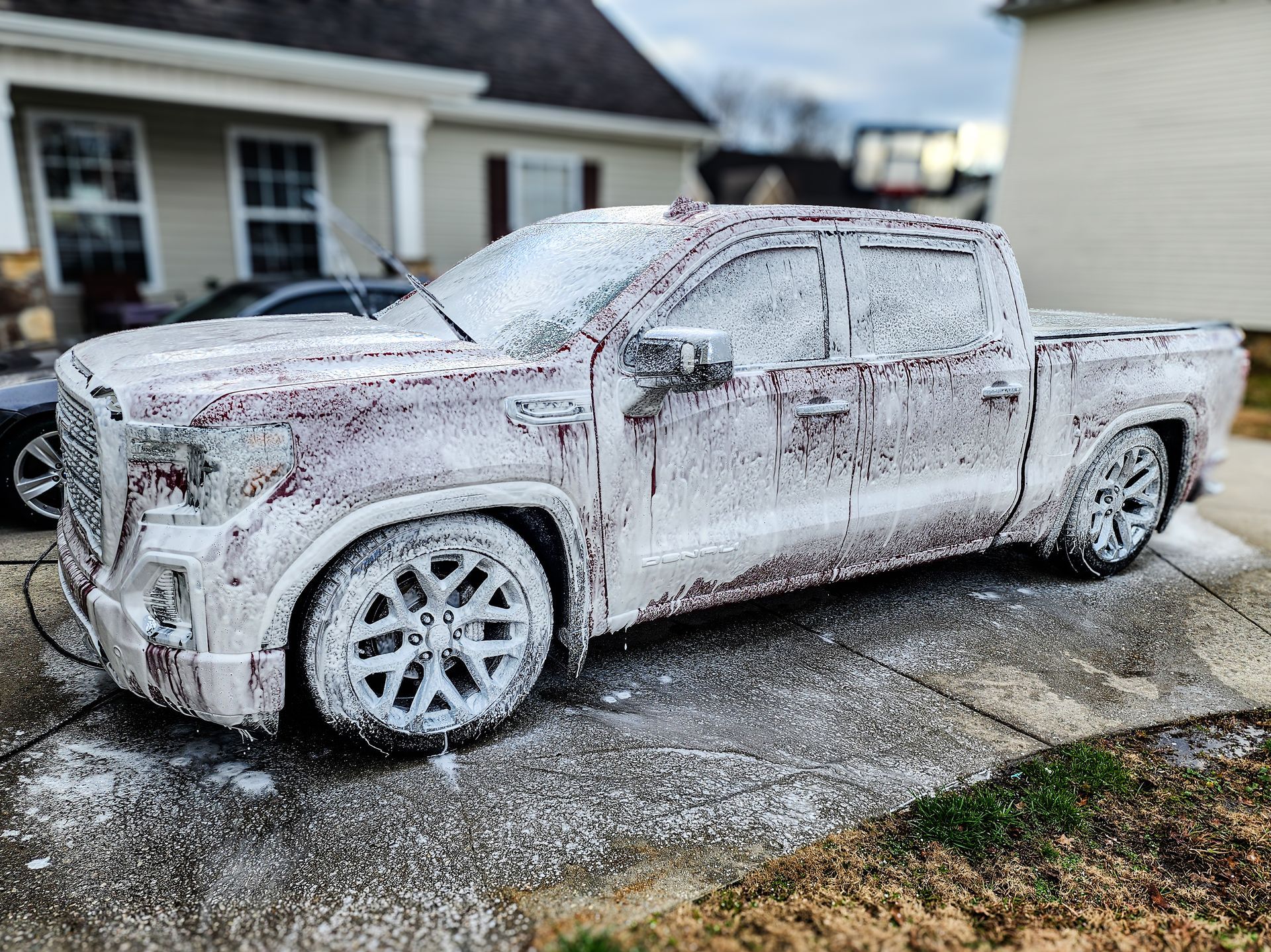 GMC Denali truck covered in wash soap foam getting ready for paint correction