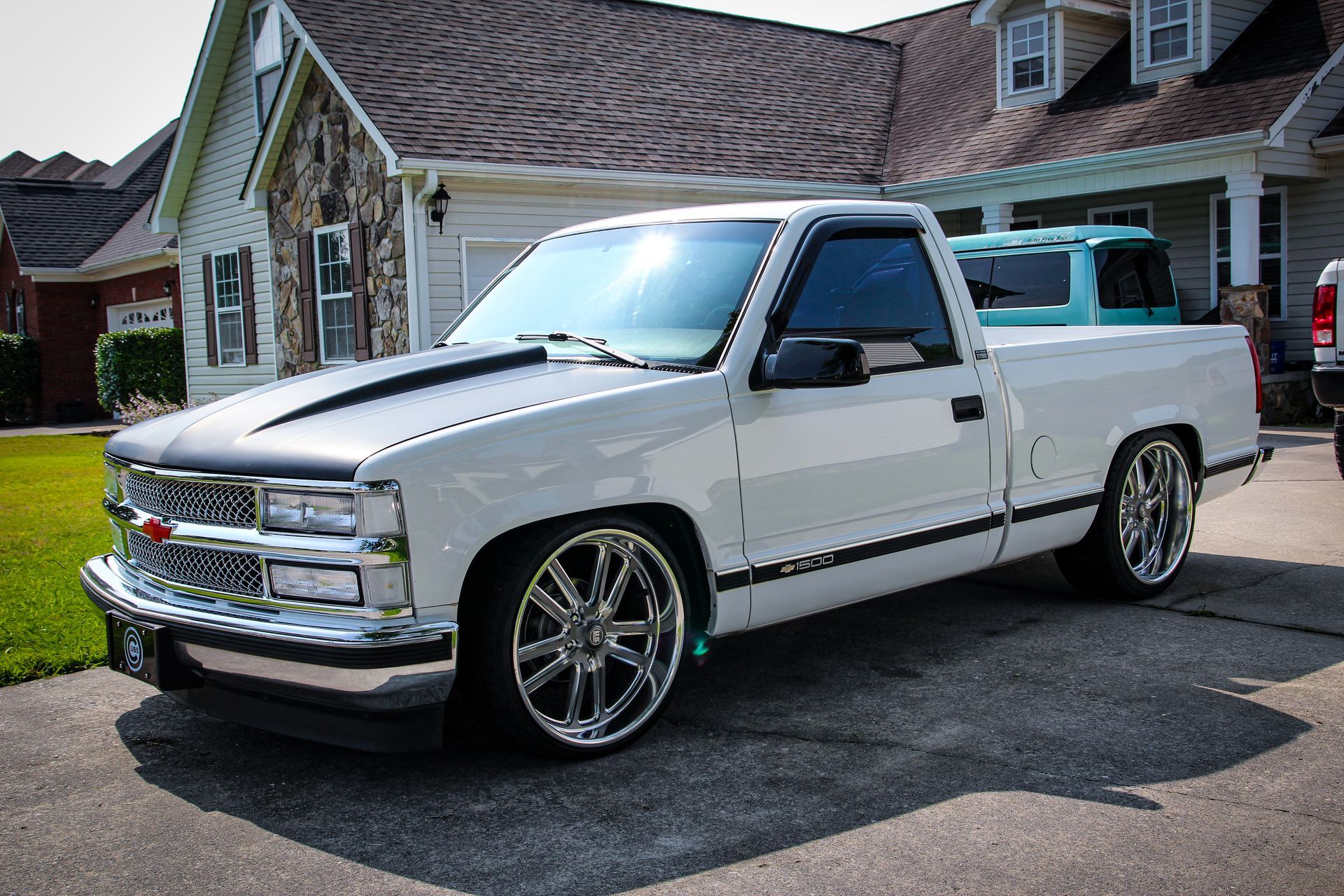 A white Chevy Silverado with a black hood reflecting in the sun after paint correction and ceramic coating in Chattanooga, TN.