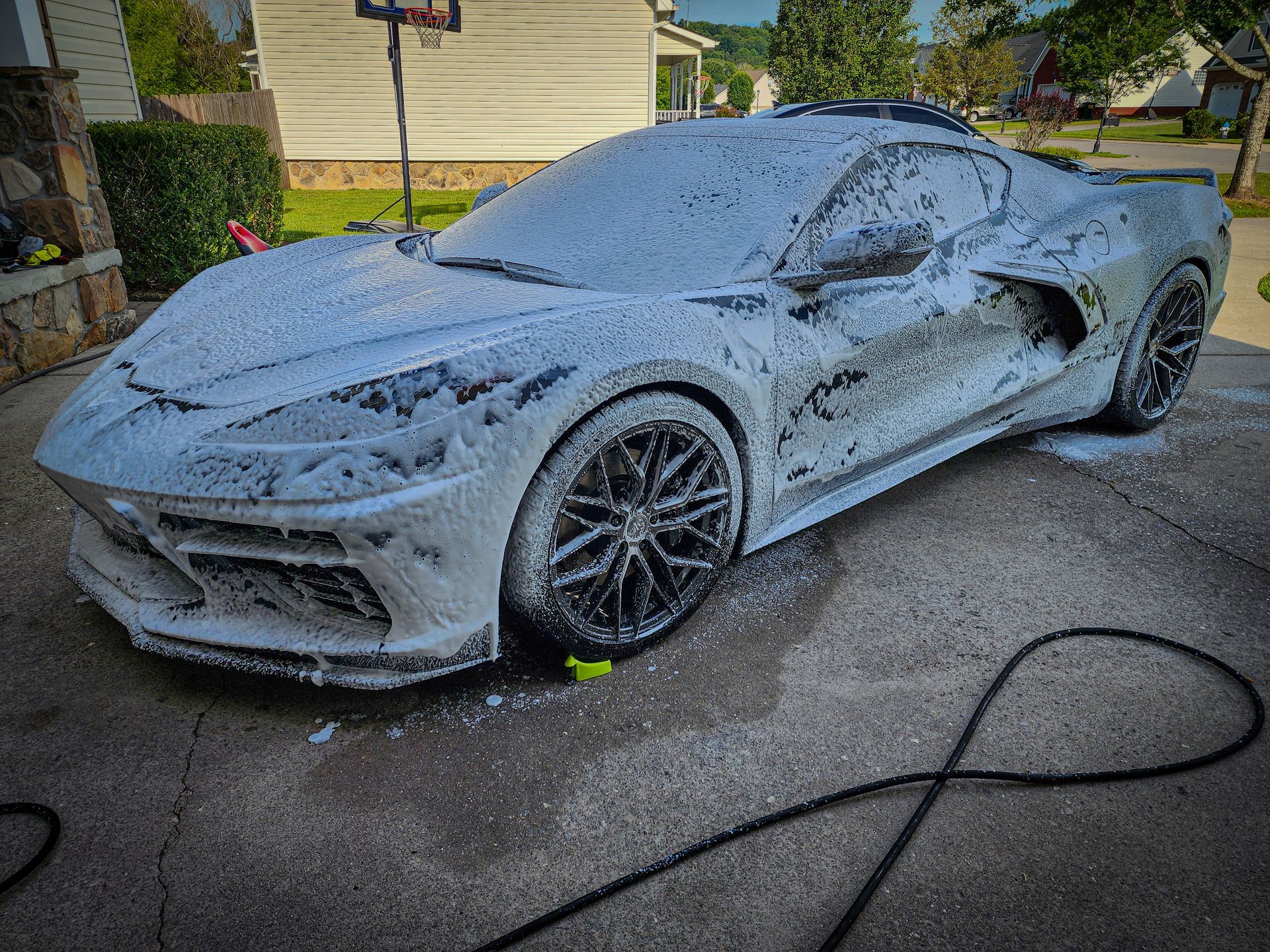 Corvette C8 covered in snow foam car wash soap by a professional detailer.